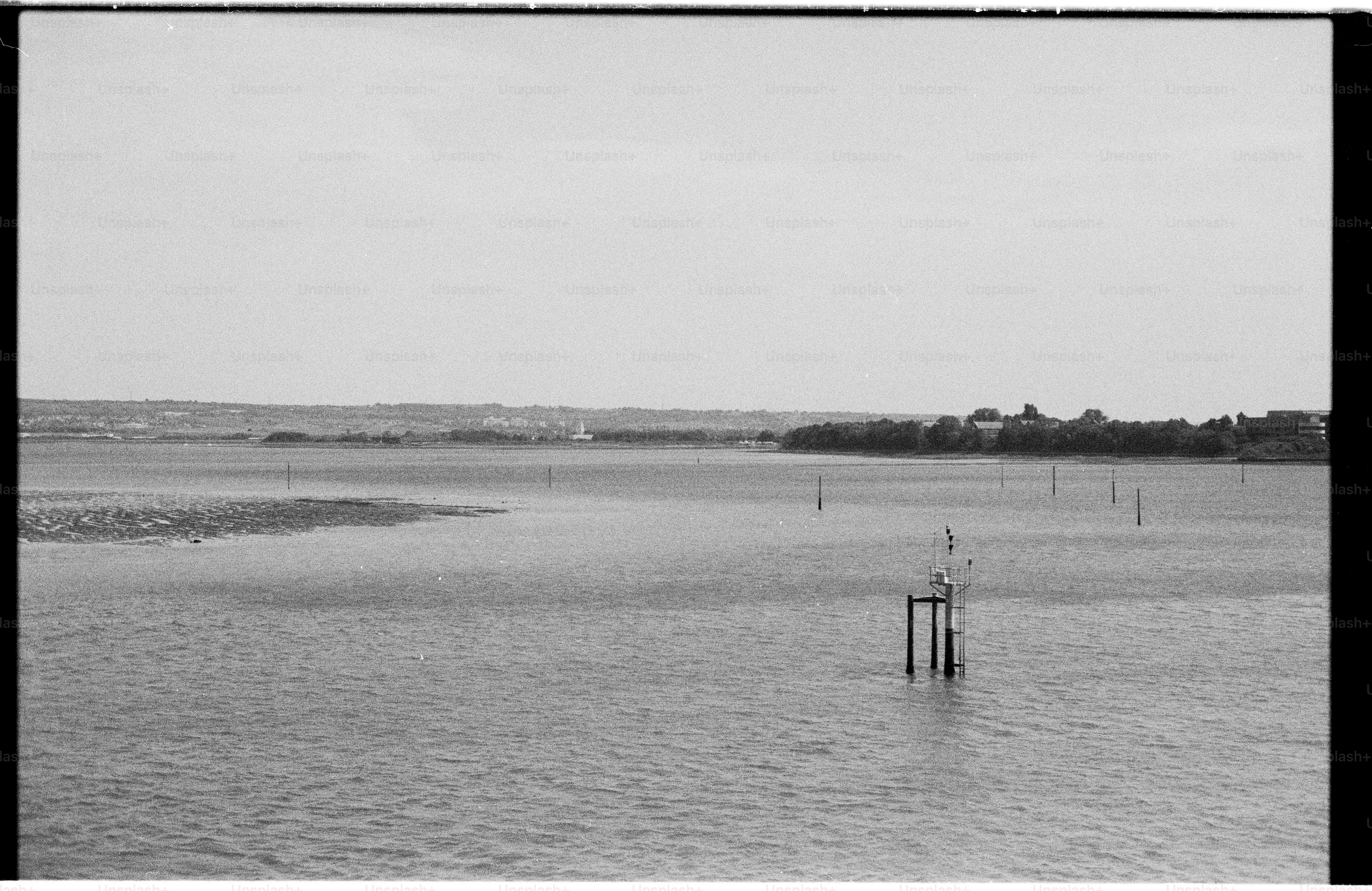 Calm water with navigation markers and distant land