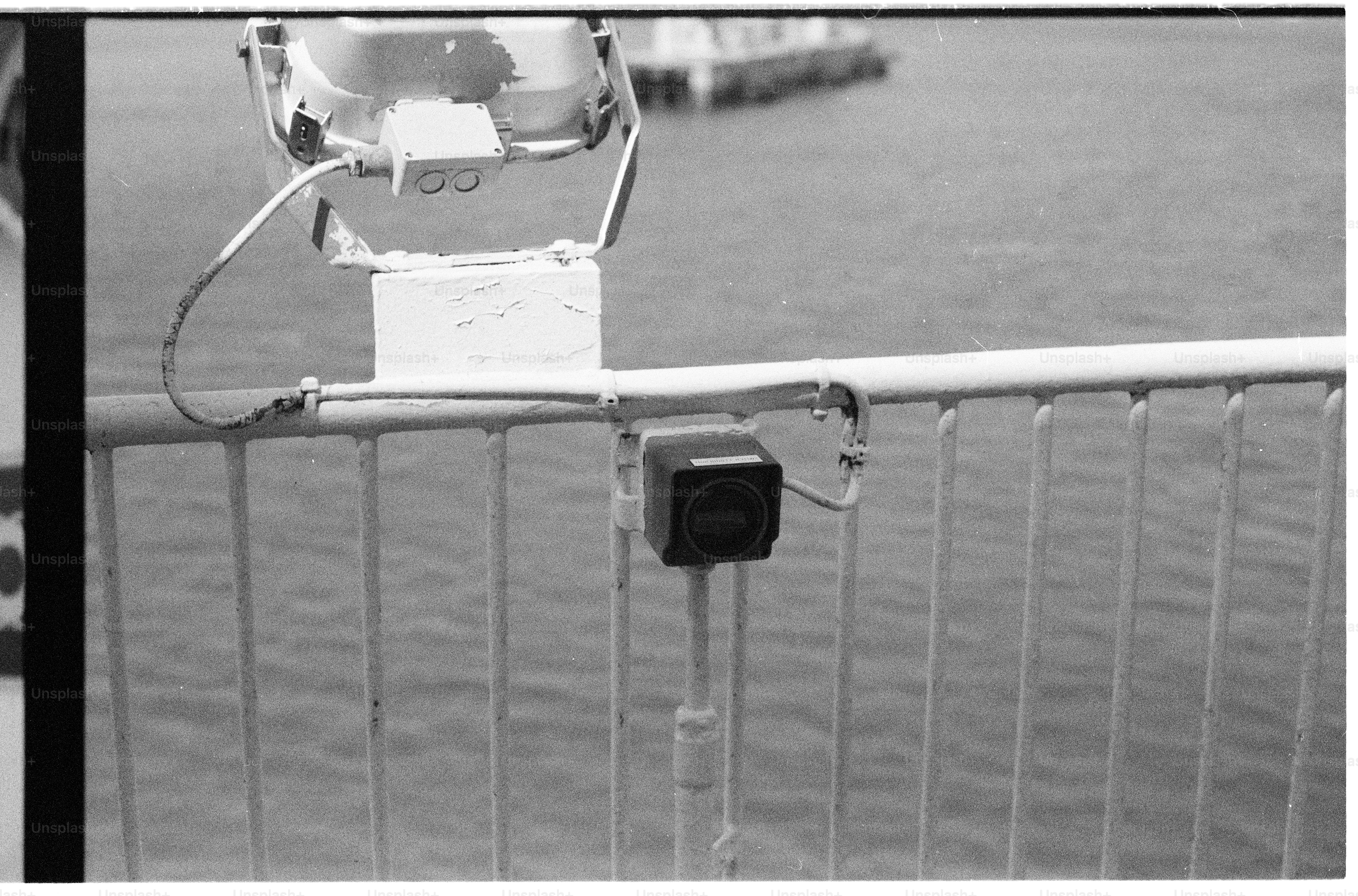 Camera and spotlight mounted on a railing above water