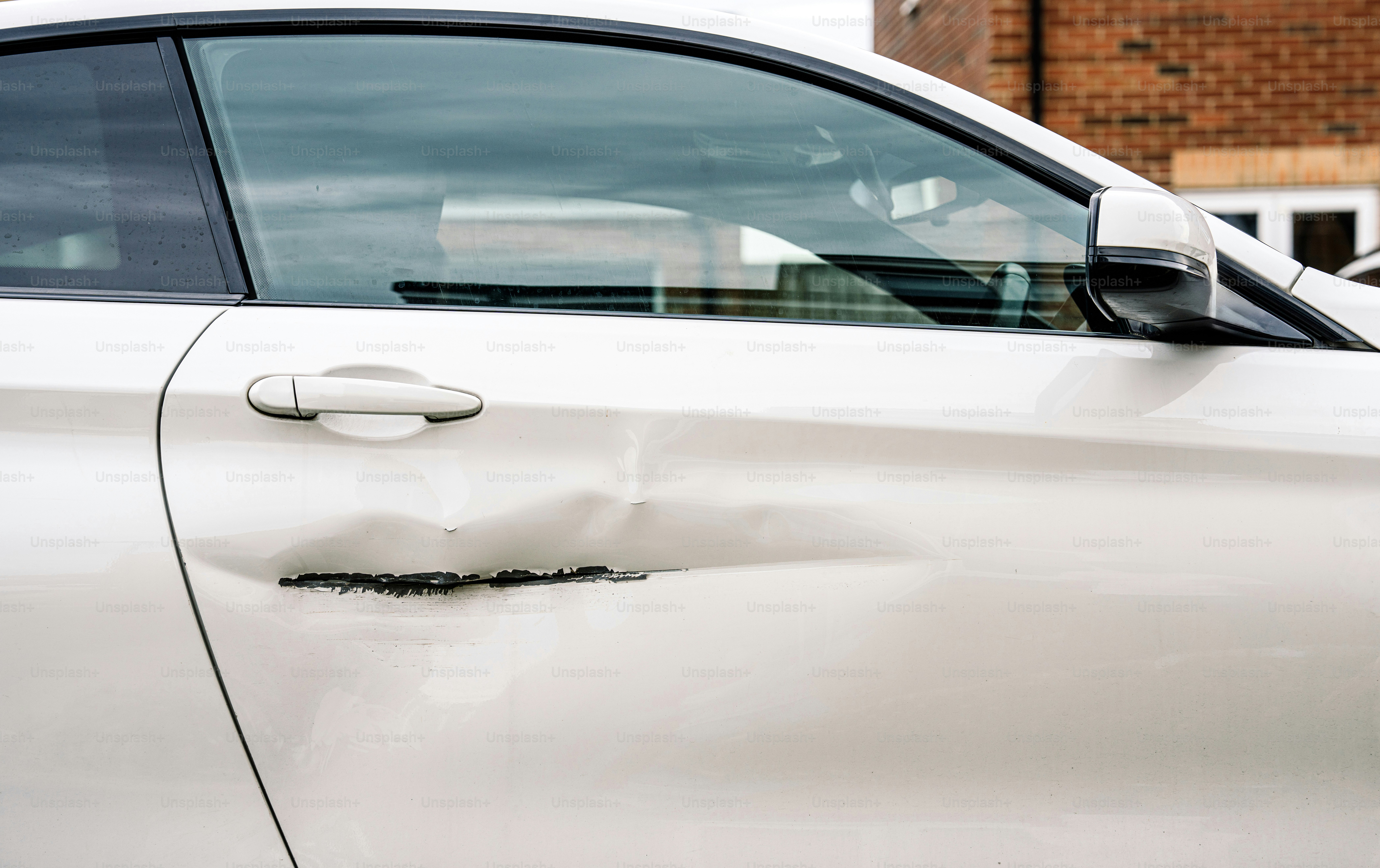 Dented, scratched white car door