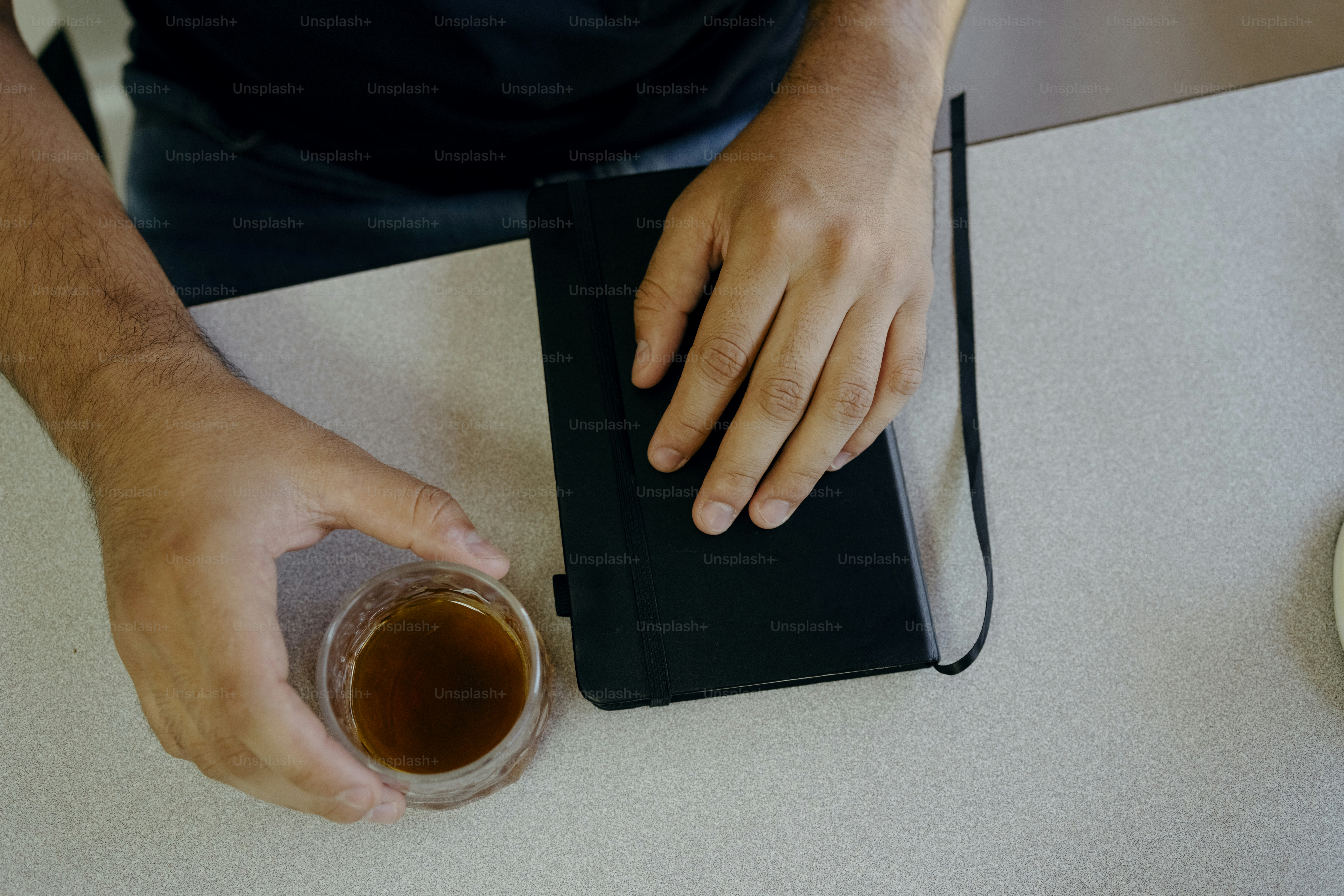 Hands with coffee cup and black notebook