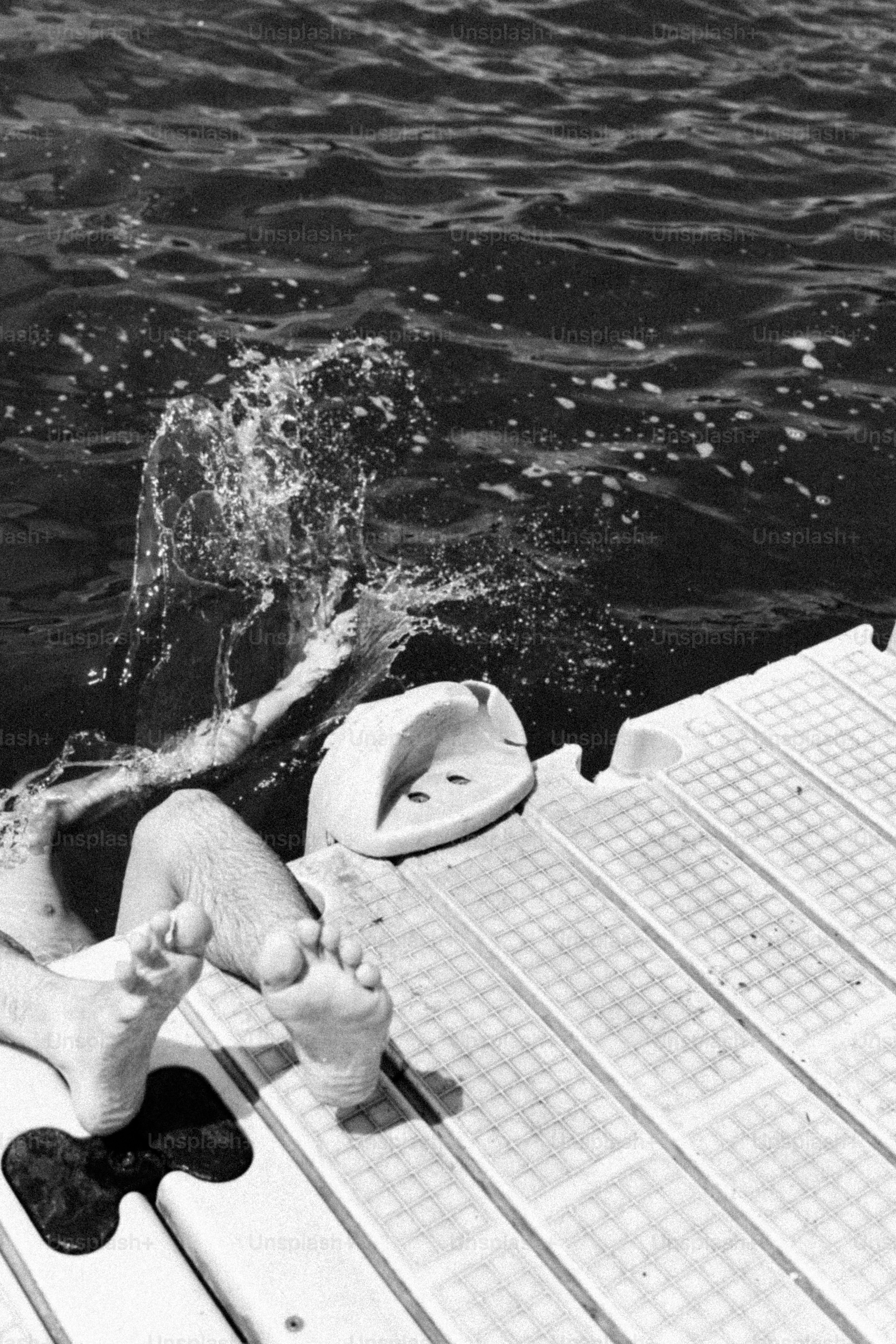 Legs on a floating dock with splashing water
