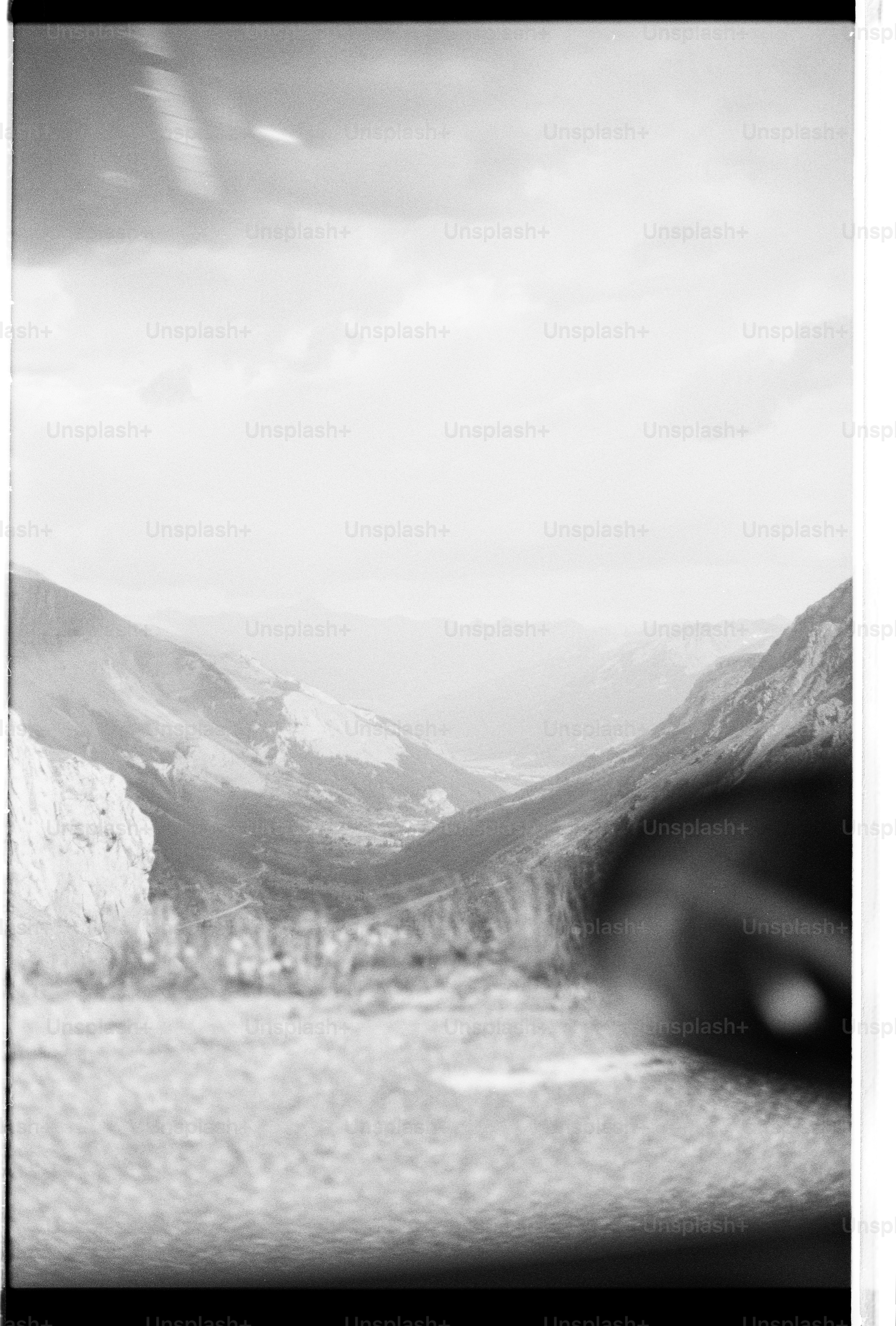 Black and white mountain valley under cloudy sky