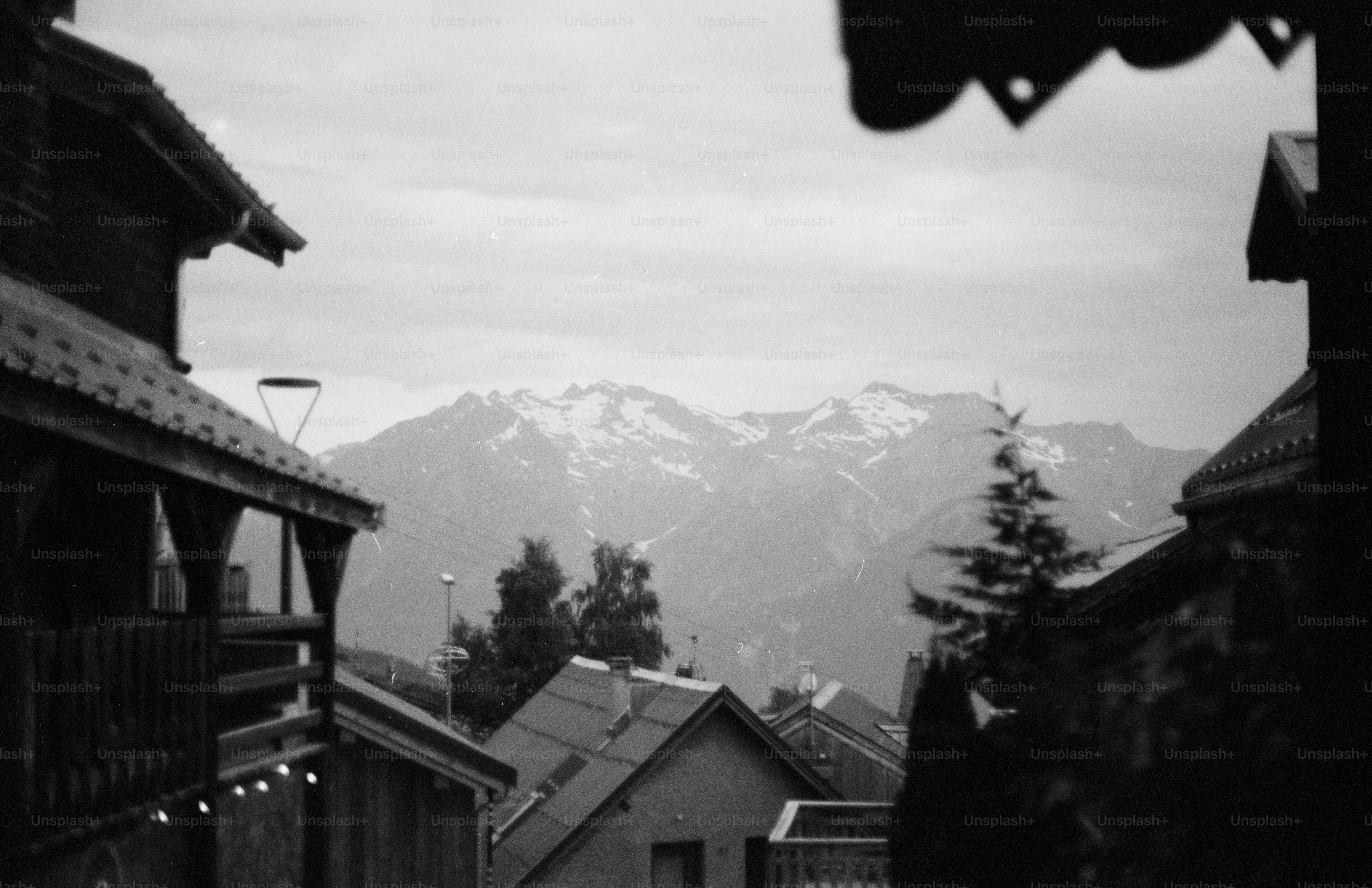 Village rooftops with snowy mountains in black and white