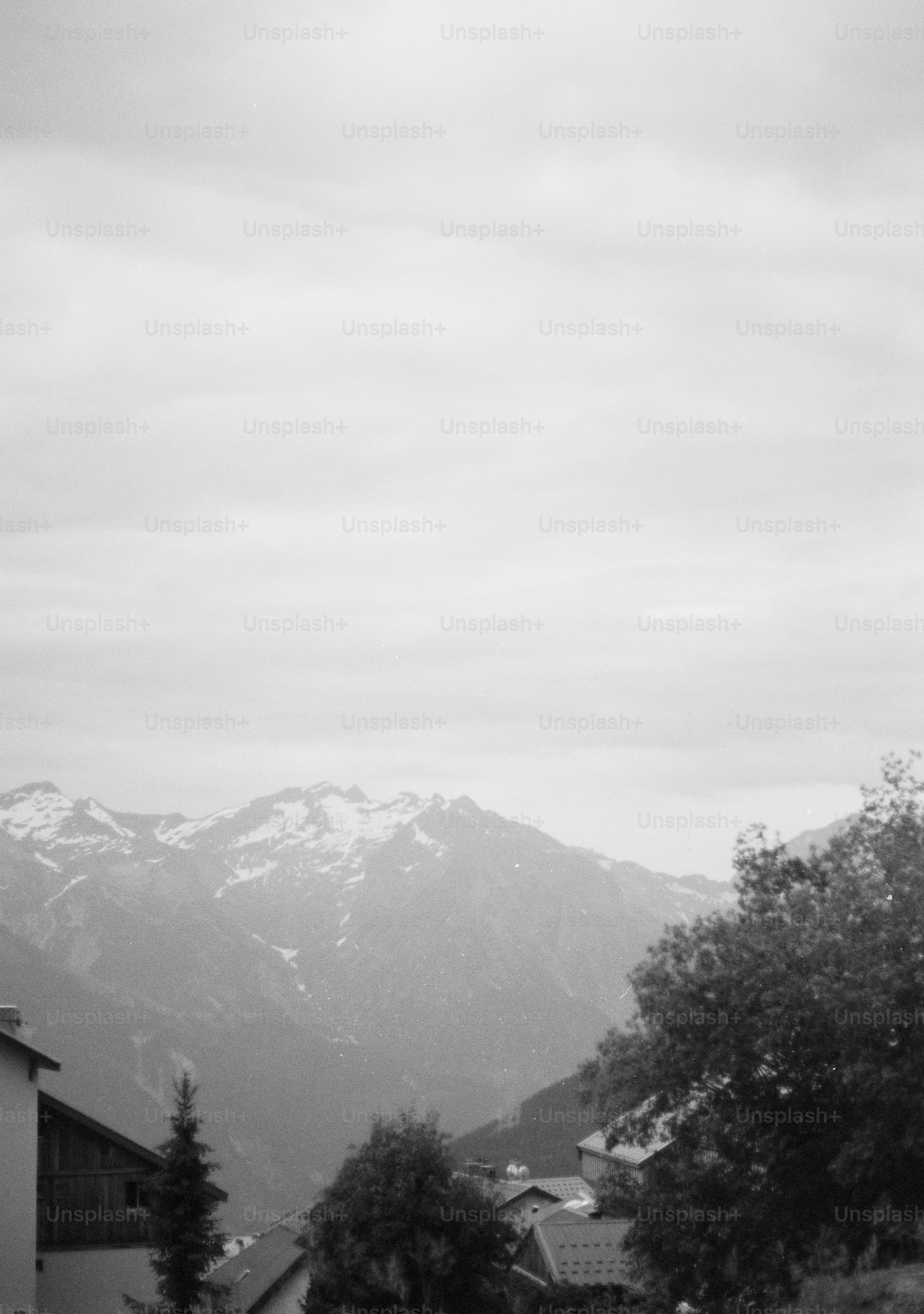 Monochrome landscape with snow-capped mountains and village