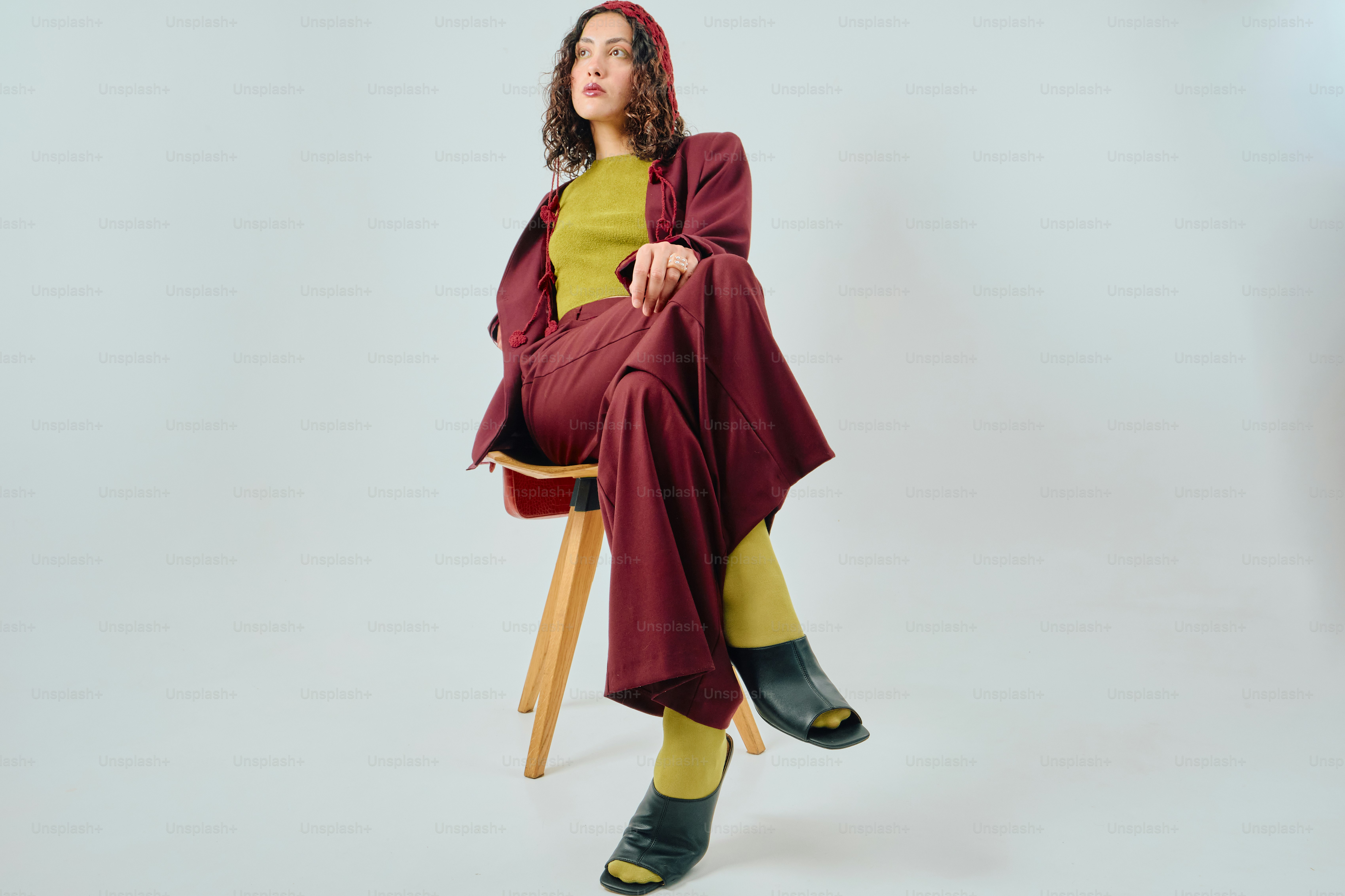 Woman in burgundy and chartreuse fashion on stool
