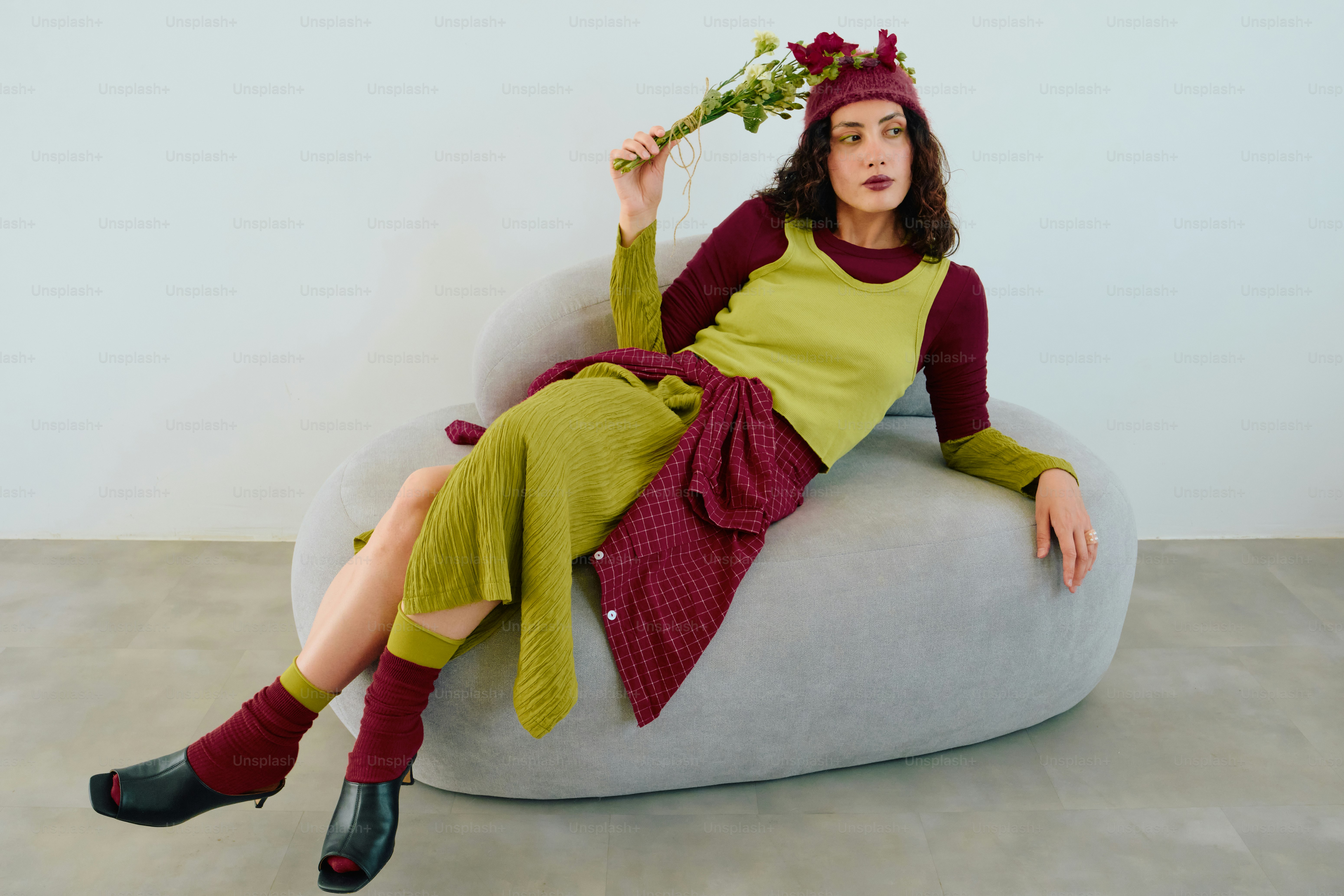 Woman in burgundy and chartreuse fashion holding flowers