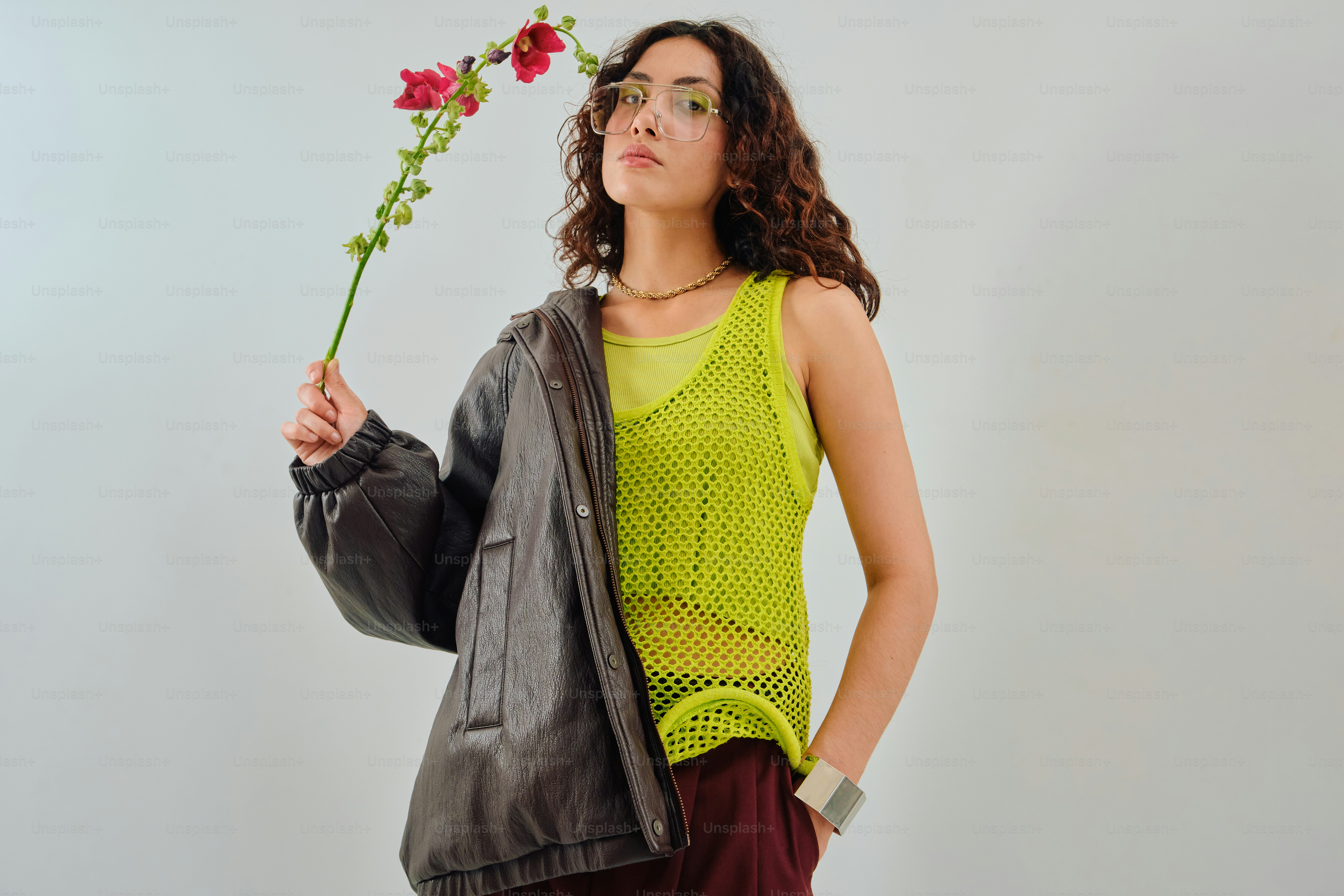 Woman in chartreuse and burgundy fashion holding red flower