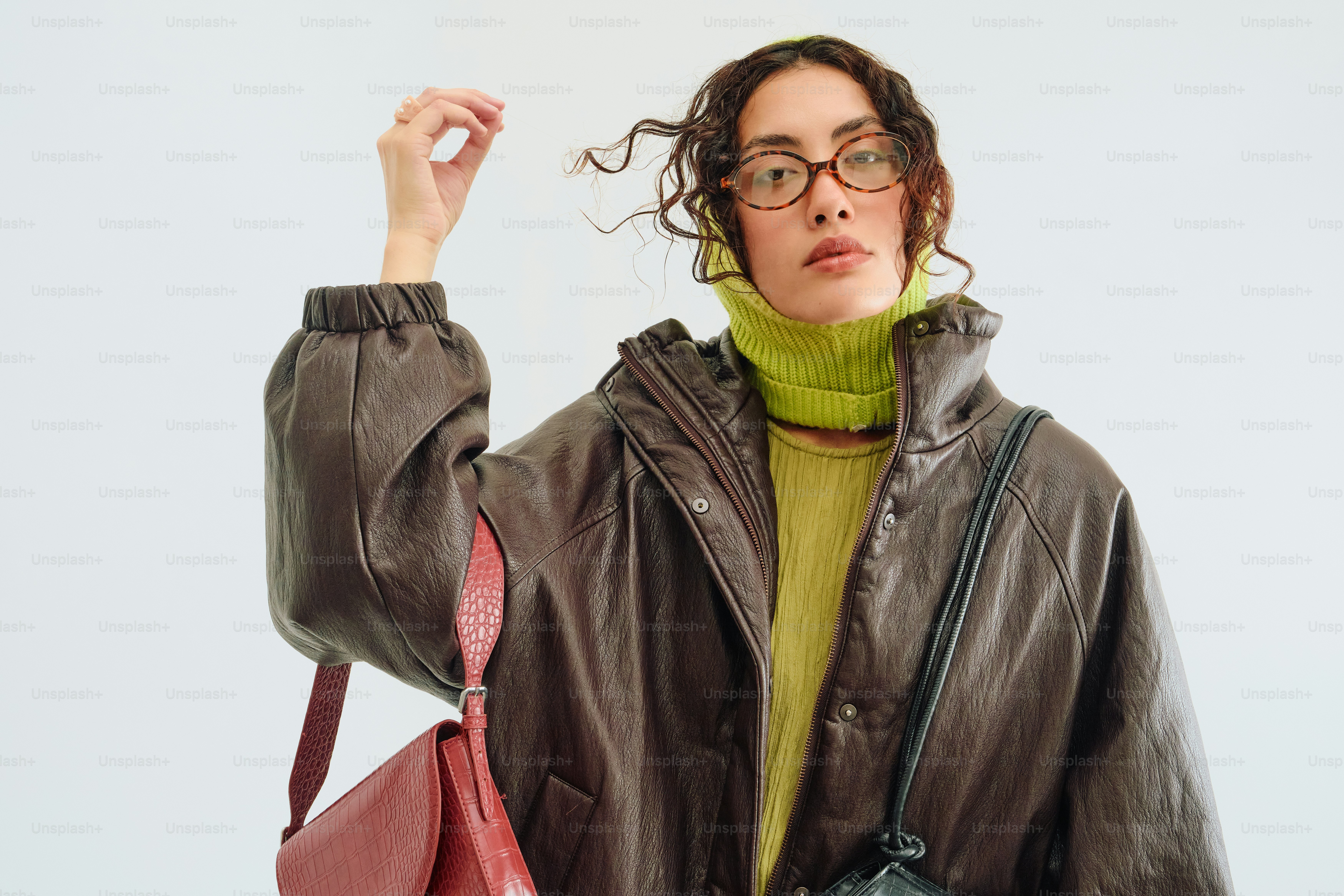 Woman in chartreuse sweater, brown jacket, burgundy bag.