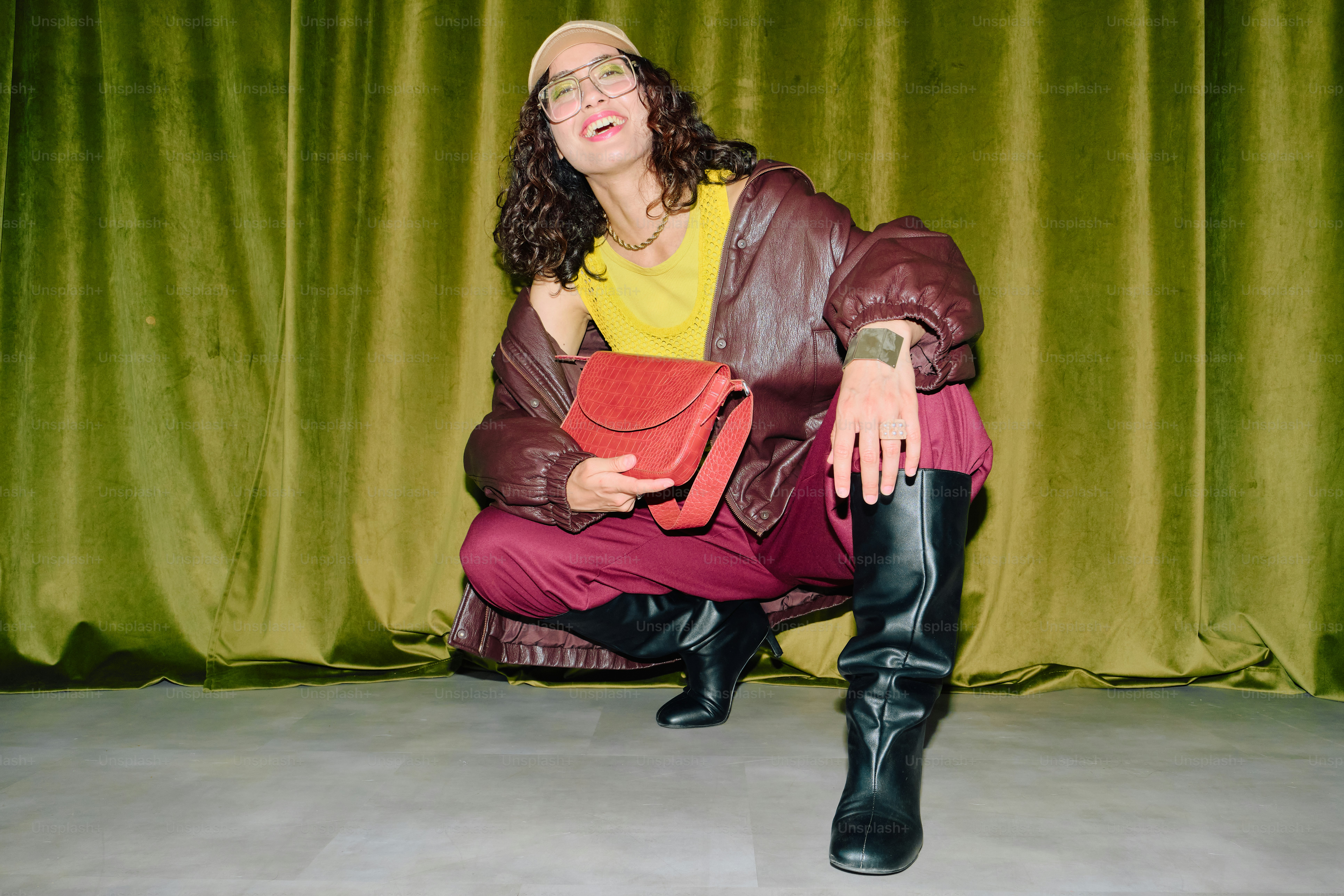 Smiling woman in burgundy and chartreuse fashion against green