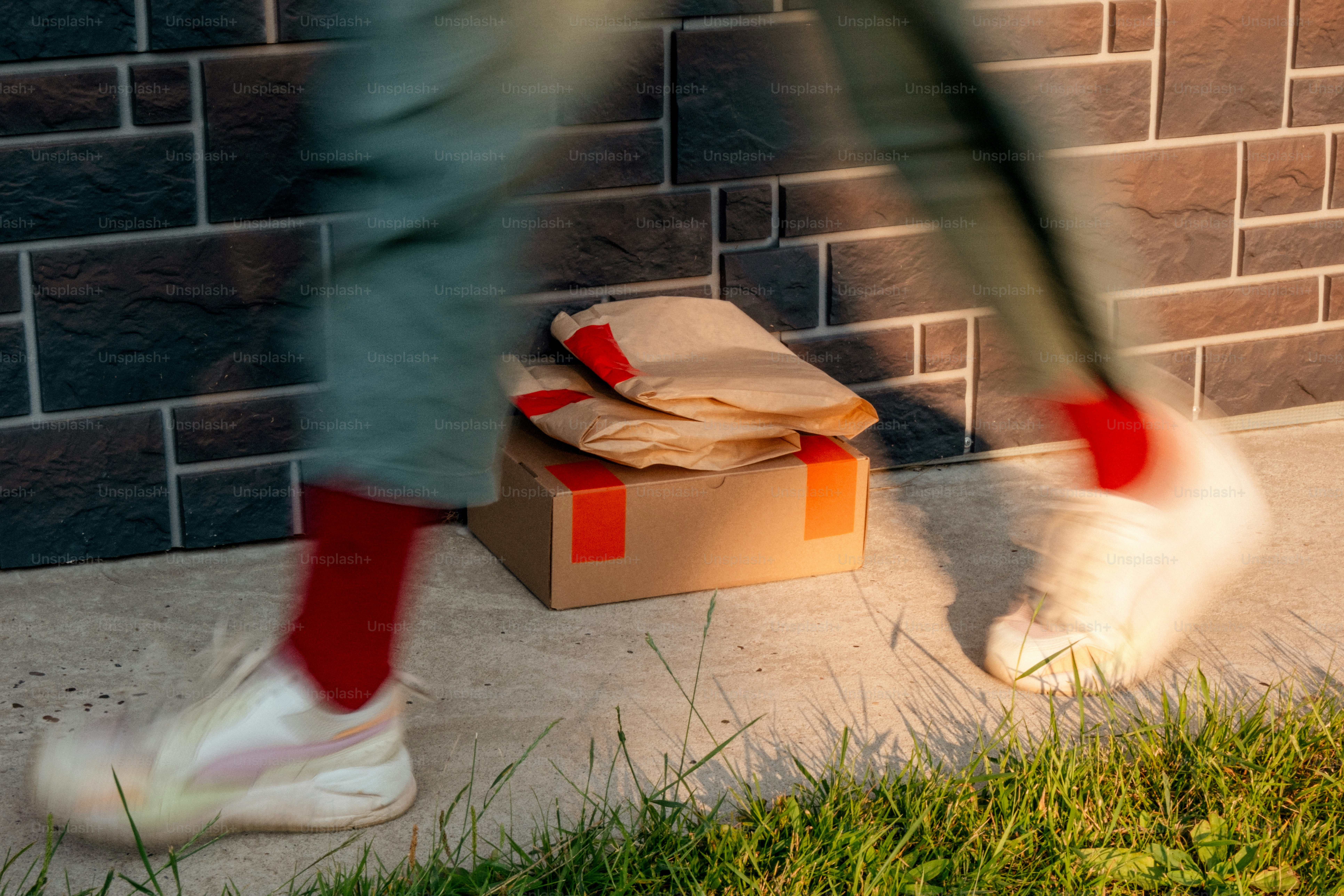 Blurred legs walking past packages and a box