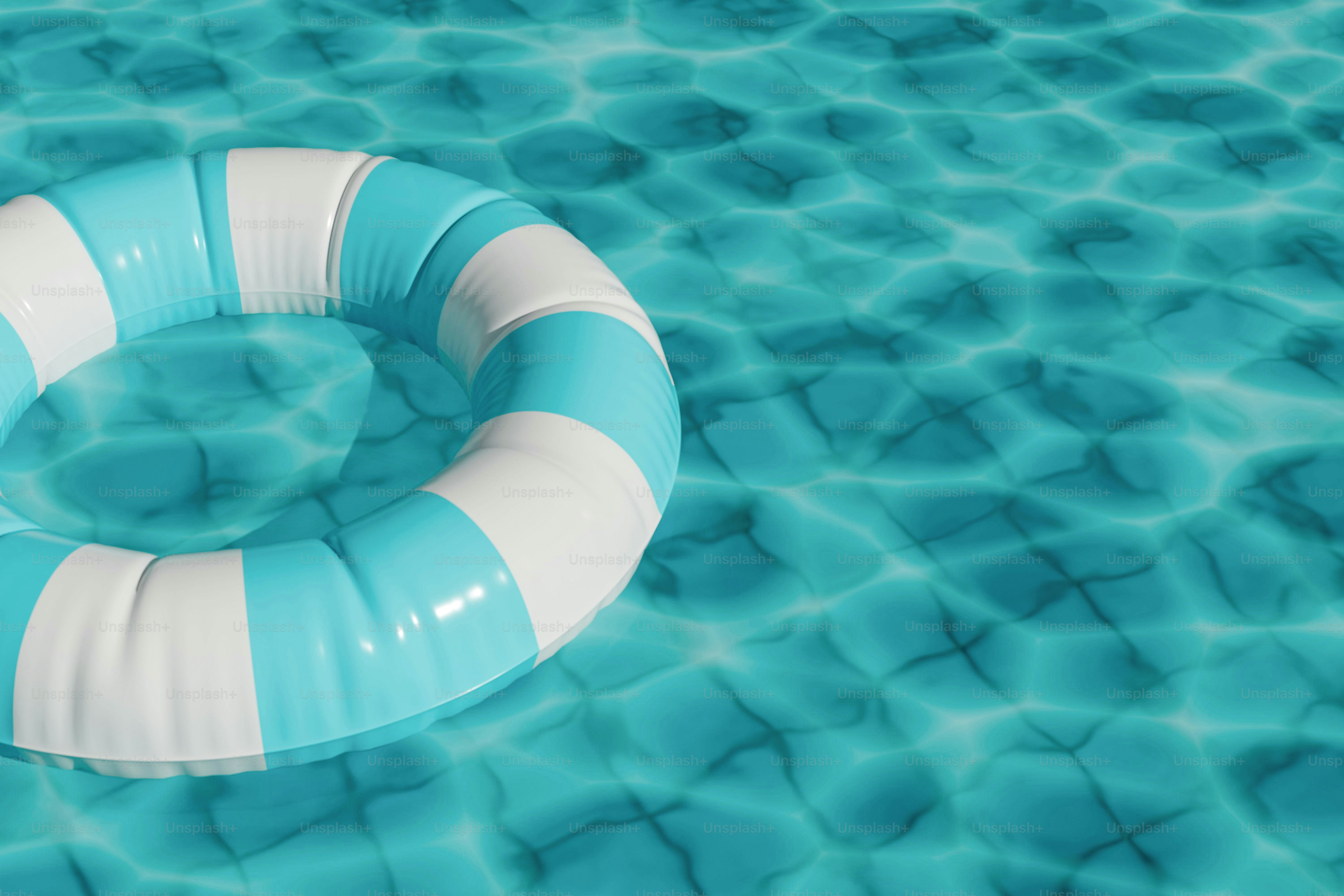 Striped lifebuoy floating in blue swimming pool water