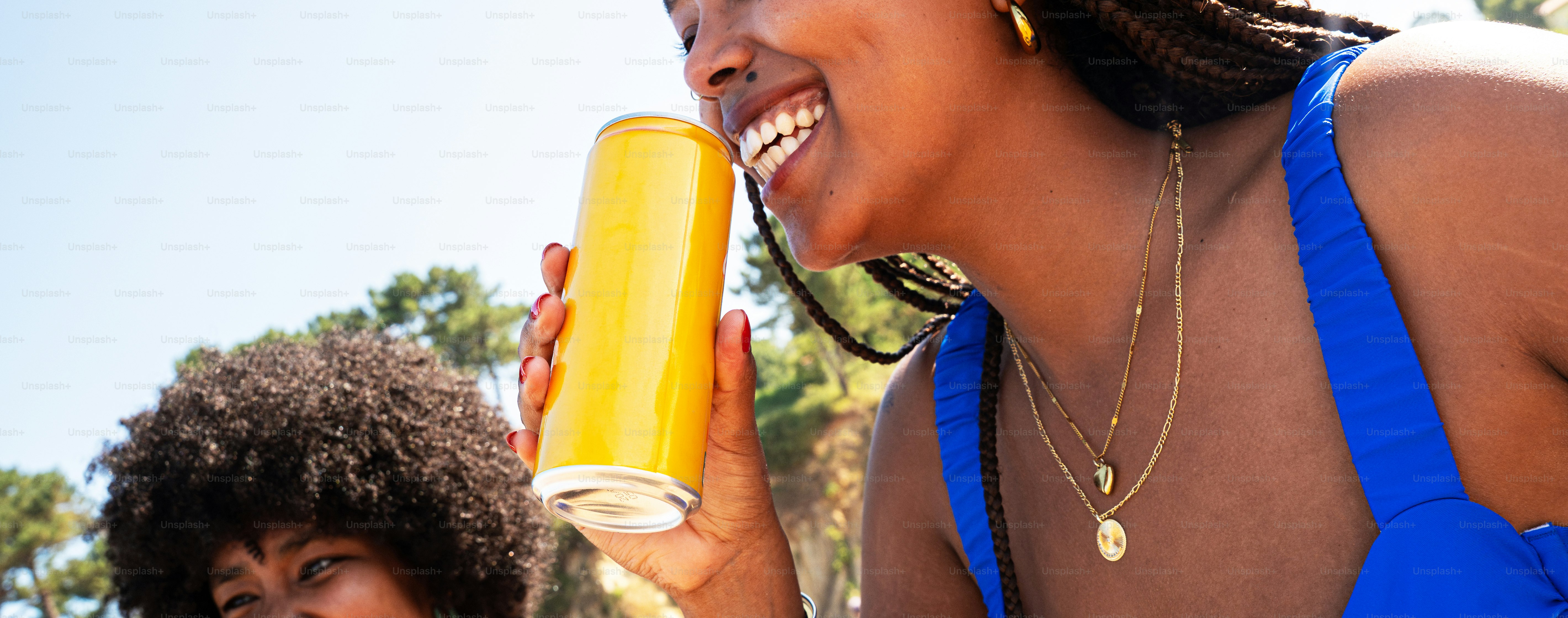 Woman laughing, holding yellow can outside