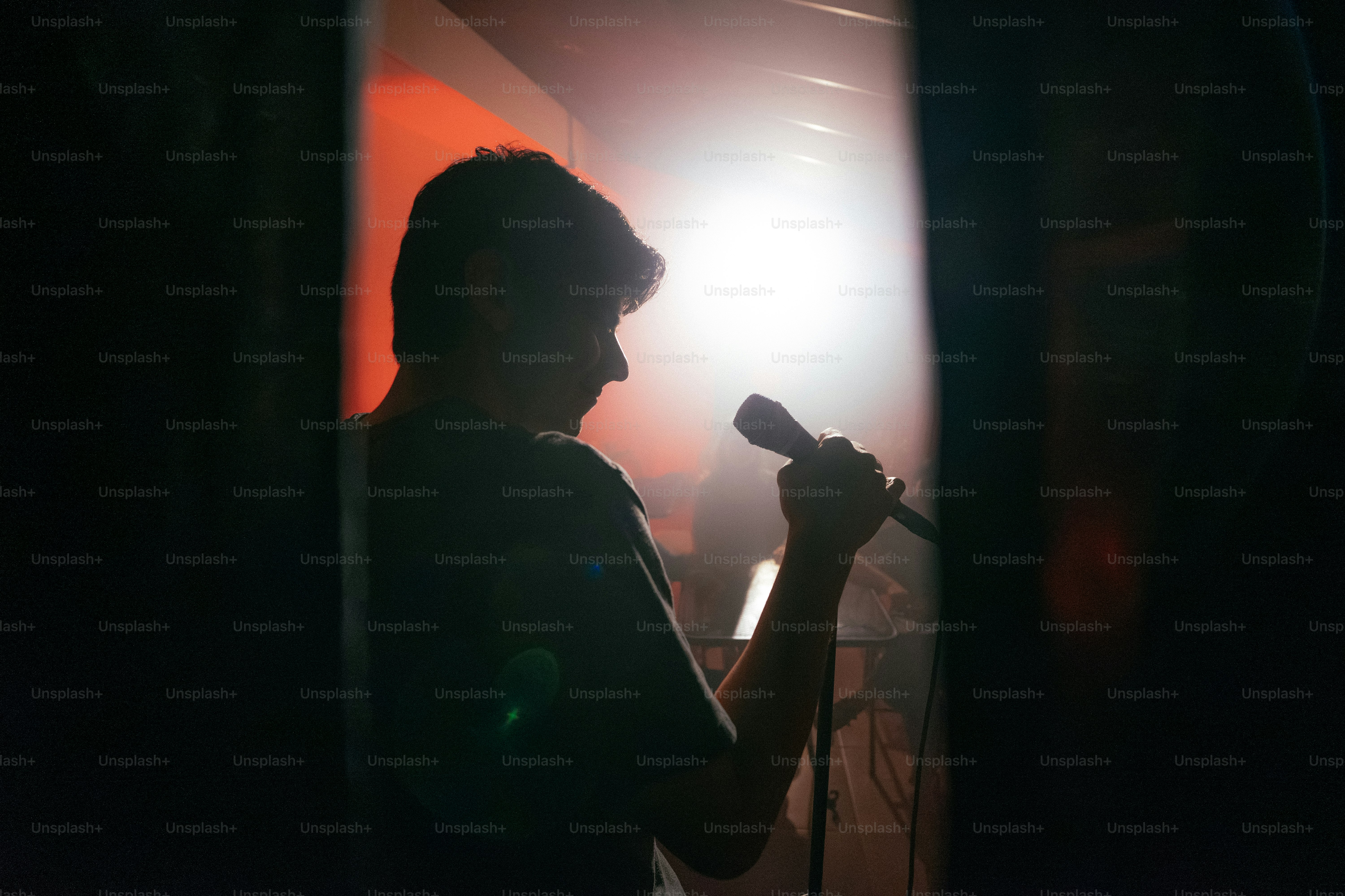 Silhouetted singer holding microphone with bright backlight