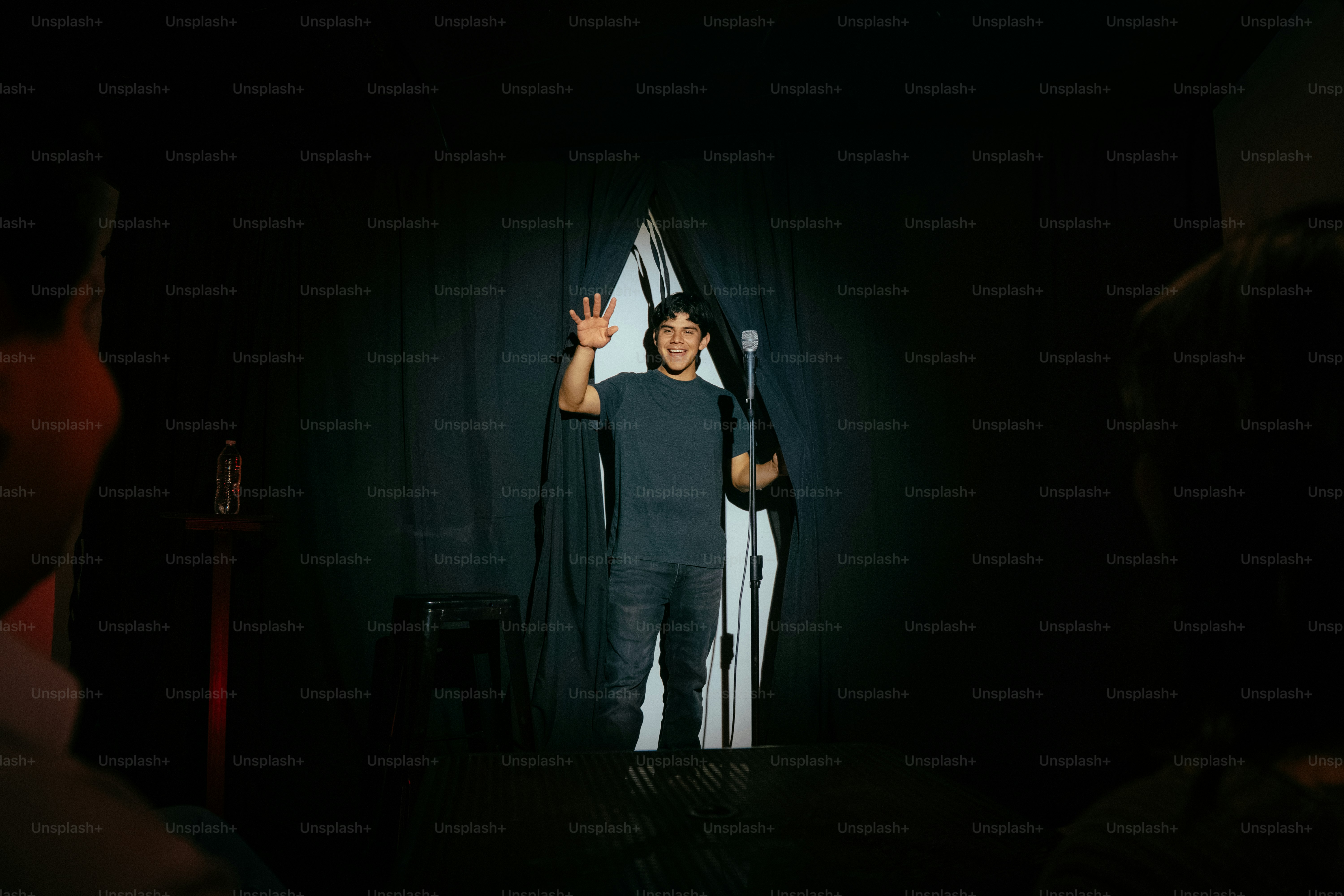Stand-up comedian waving on stage with microphone