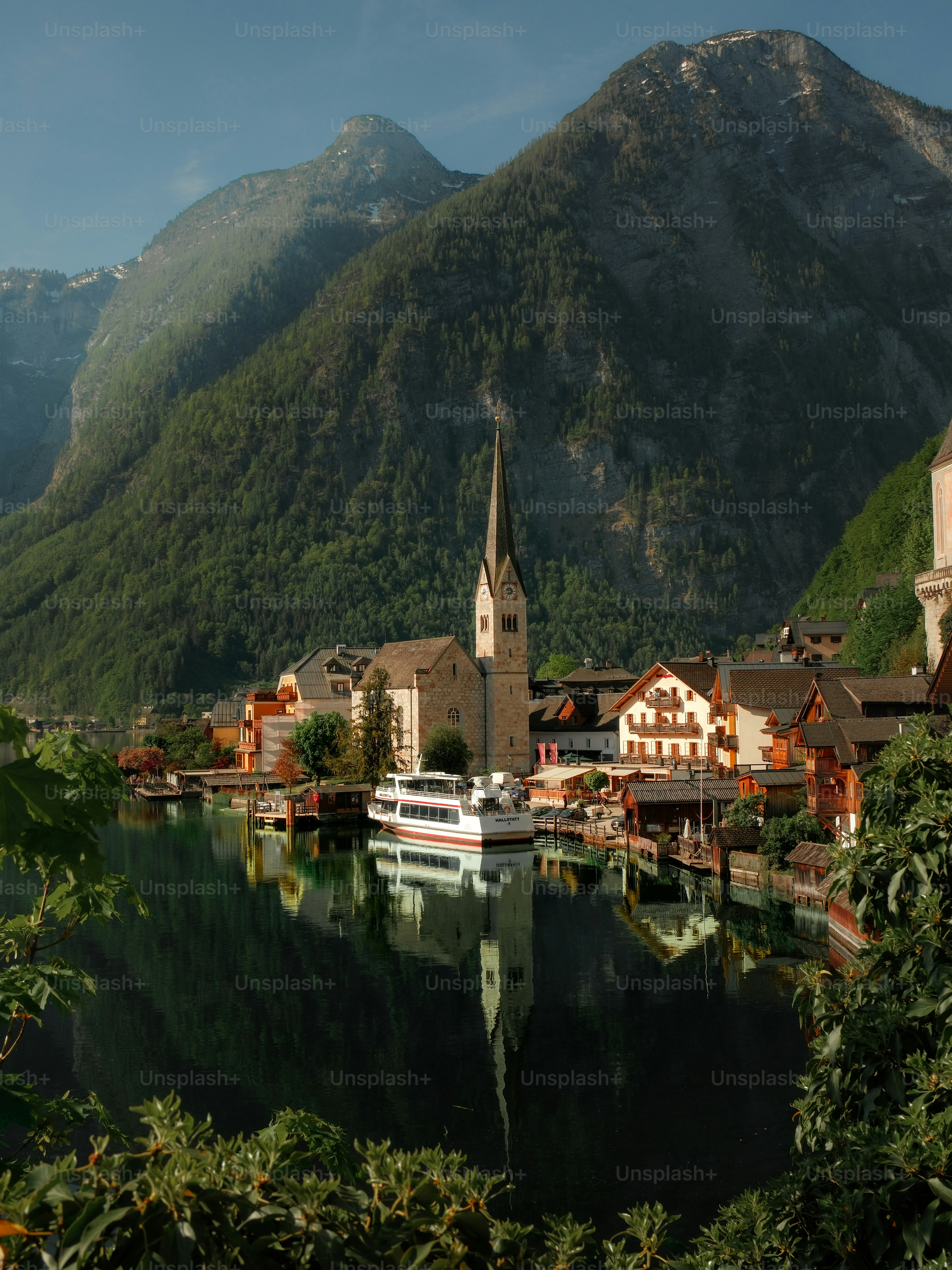 Desa alpine di danau dengan gereja dan pegunungan