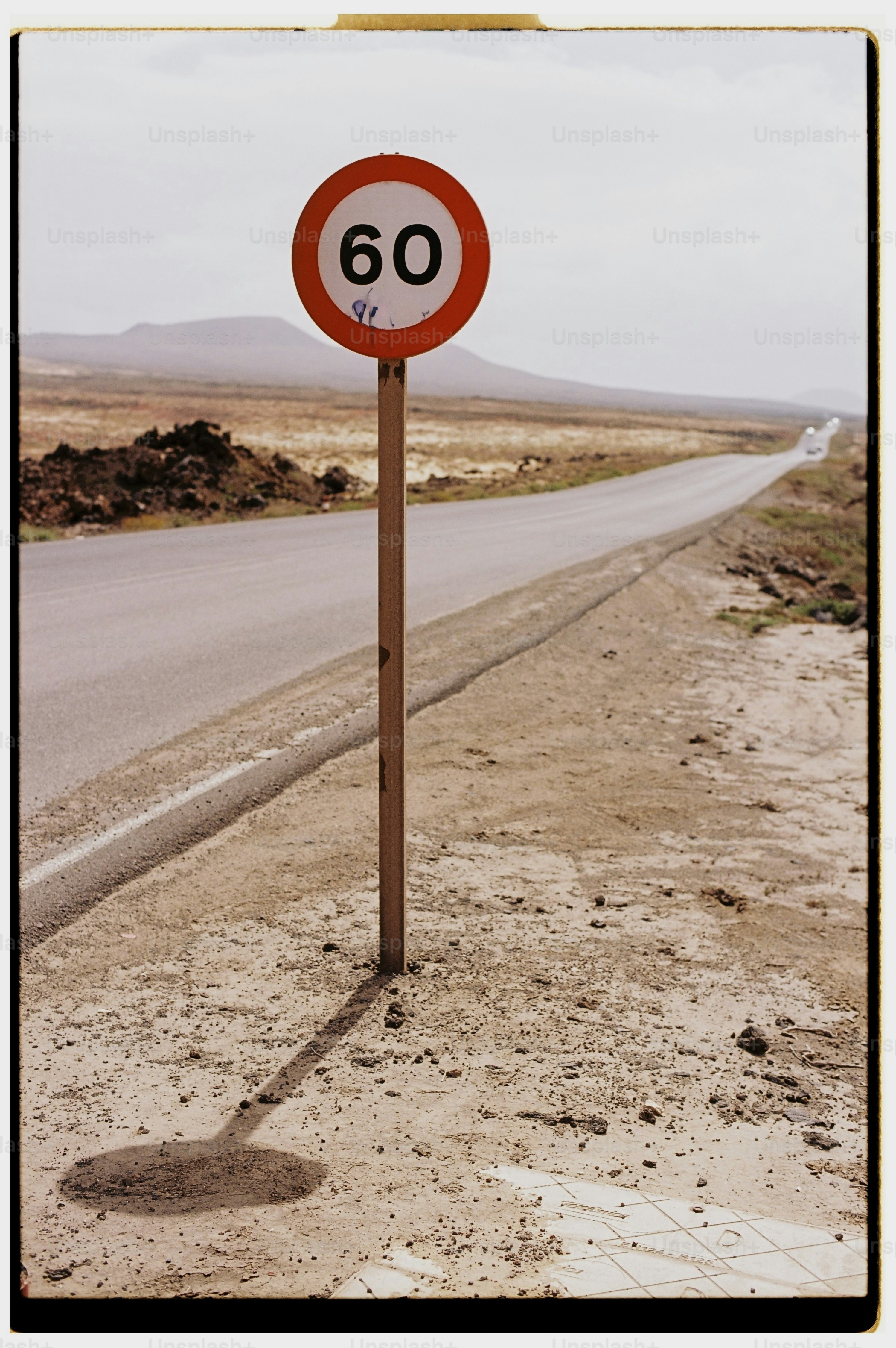 Speed limit 60 sign on a long desert road