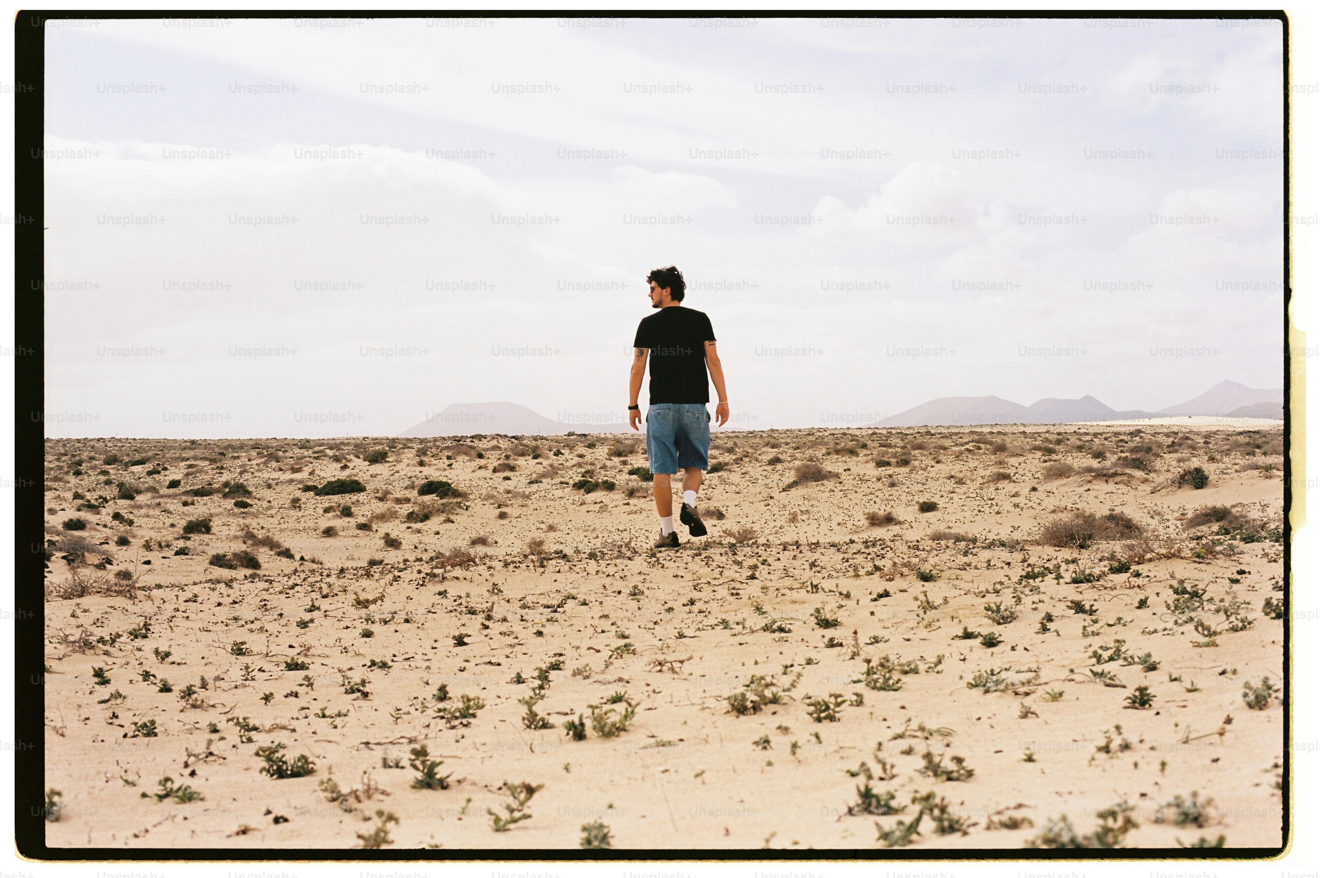 Man walking through a vast desert landscape