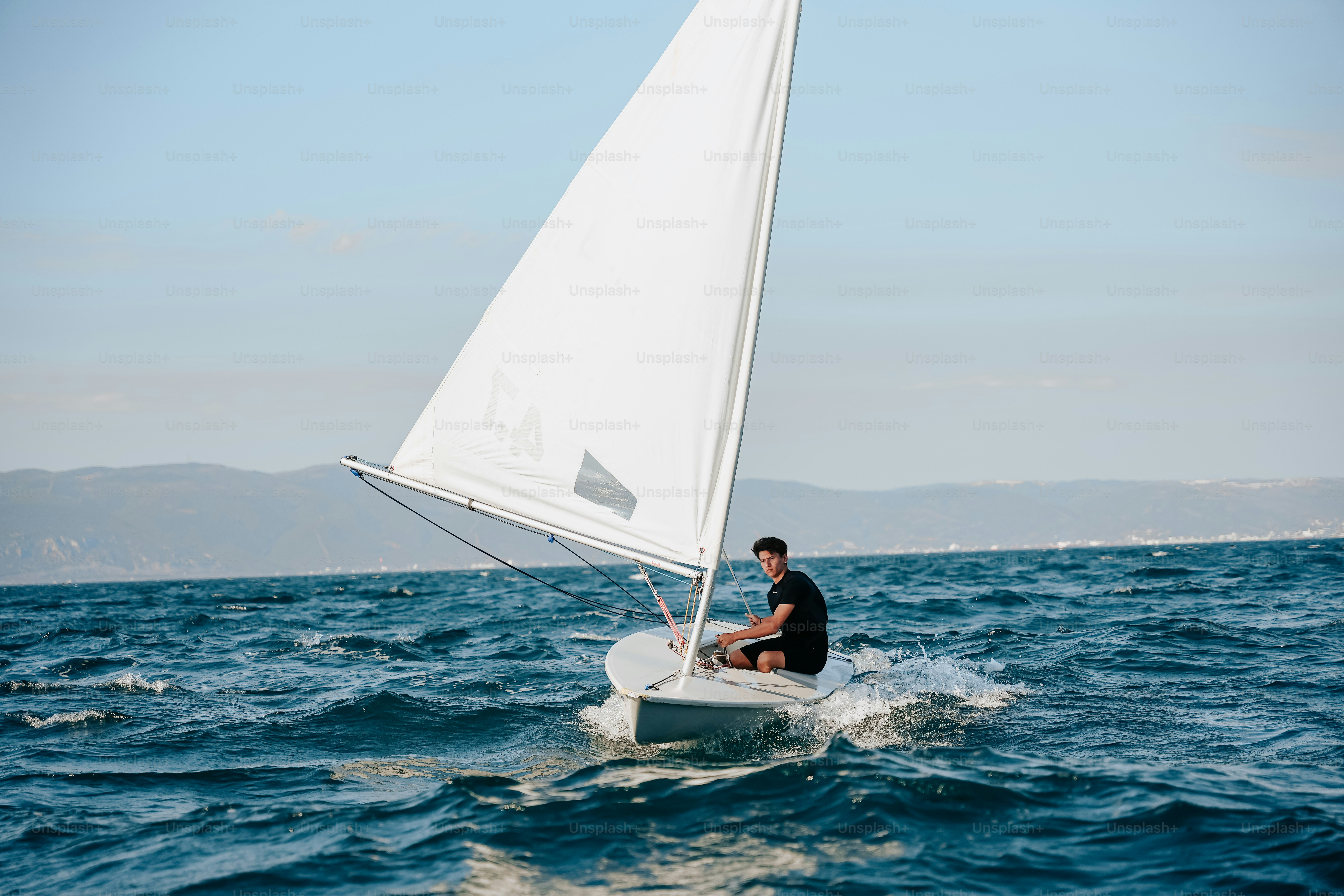 Man sailing small boat on choppy water