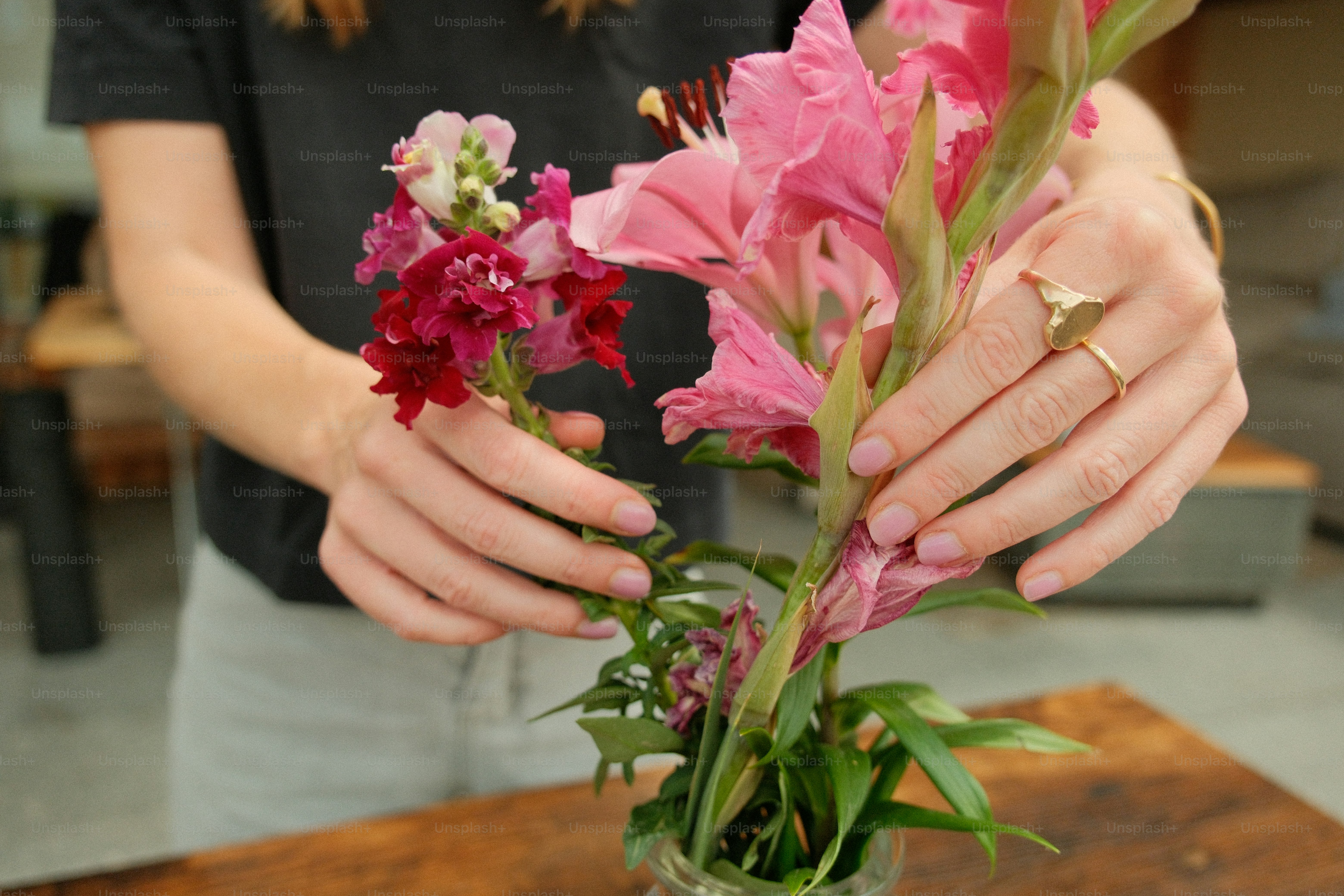 Woman's hands arranging pink and red flowers