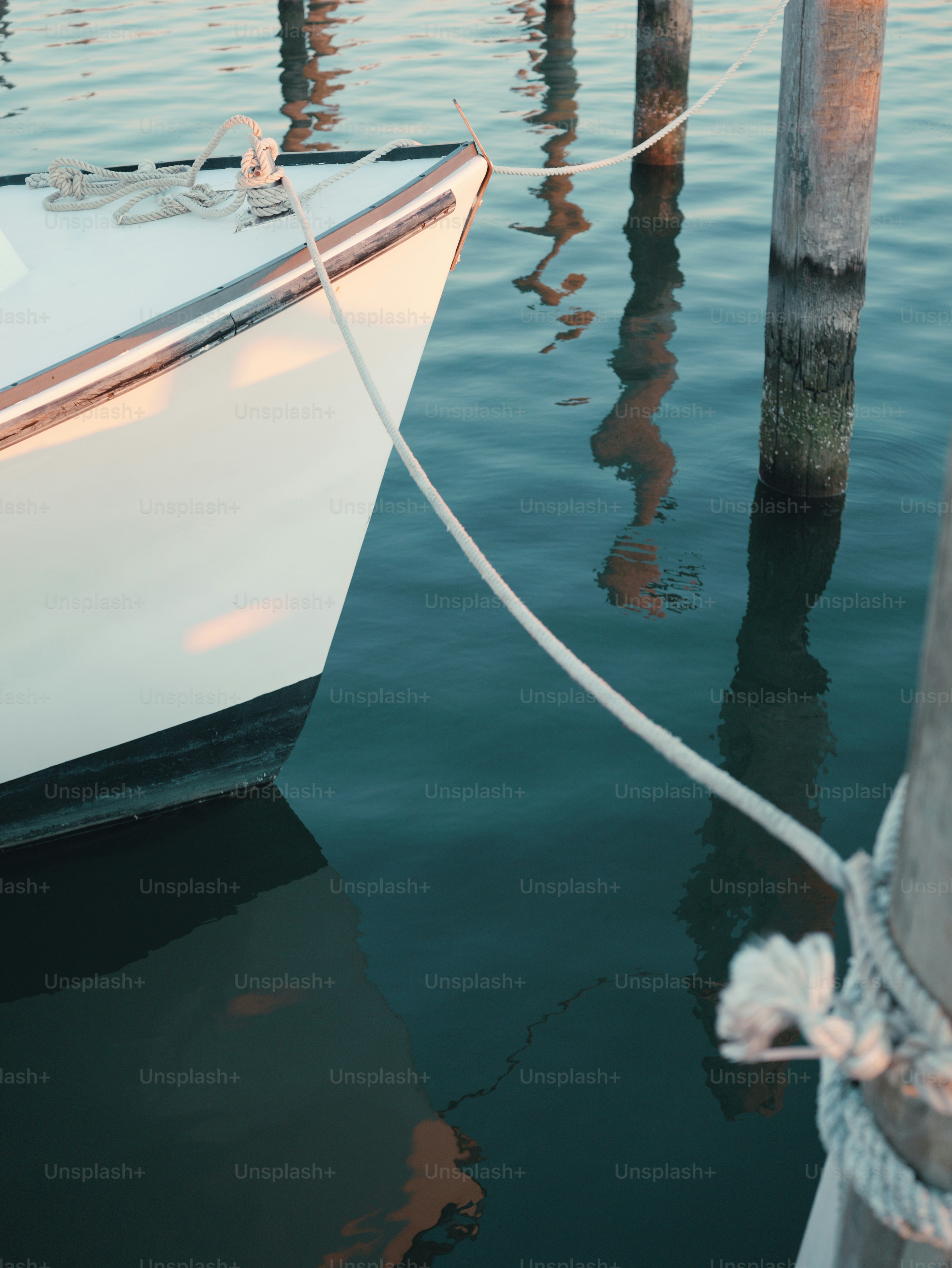 Docked boat bow and mooring lines reflecting in water
