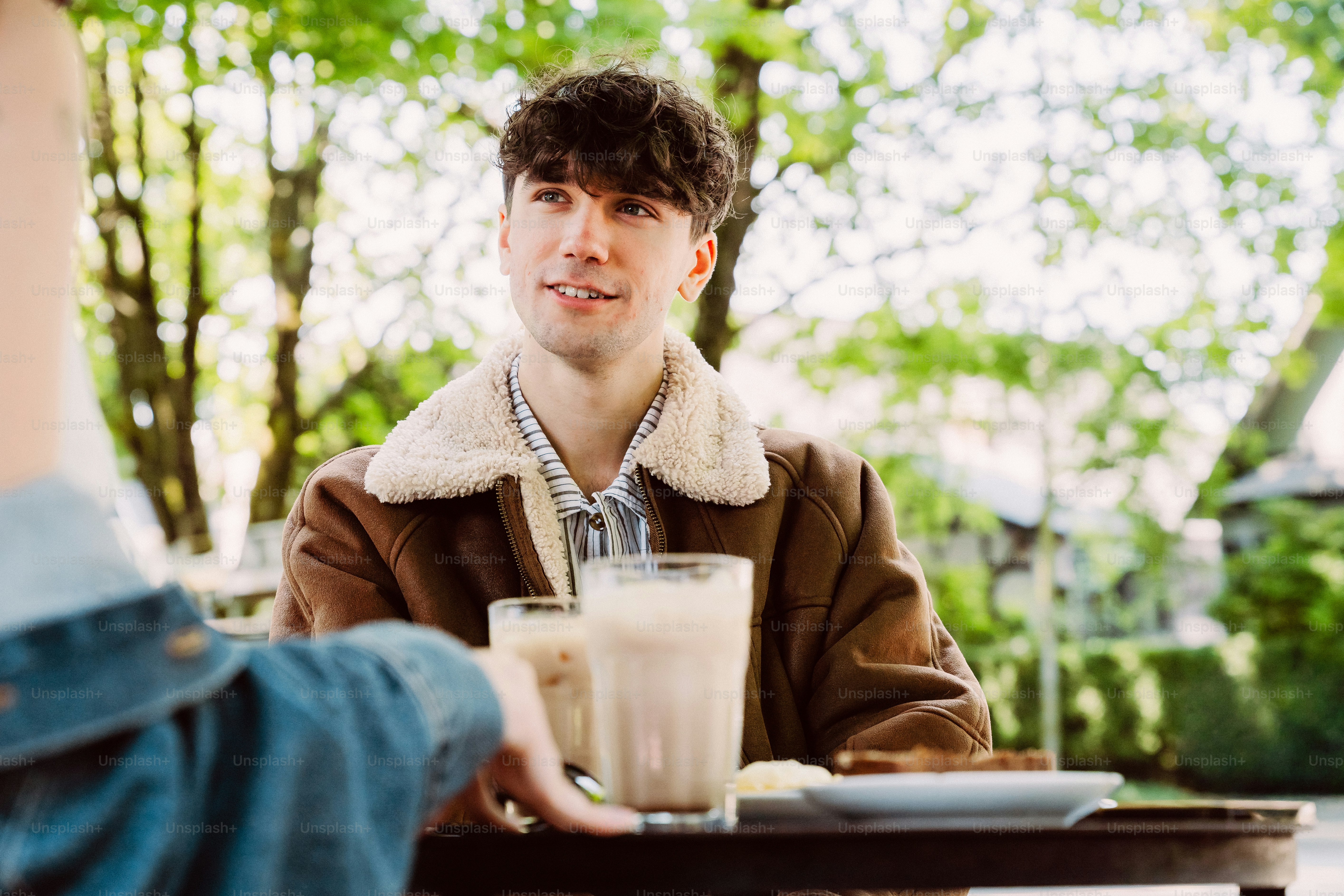 Young man smiling at outdoor cafe table