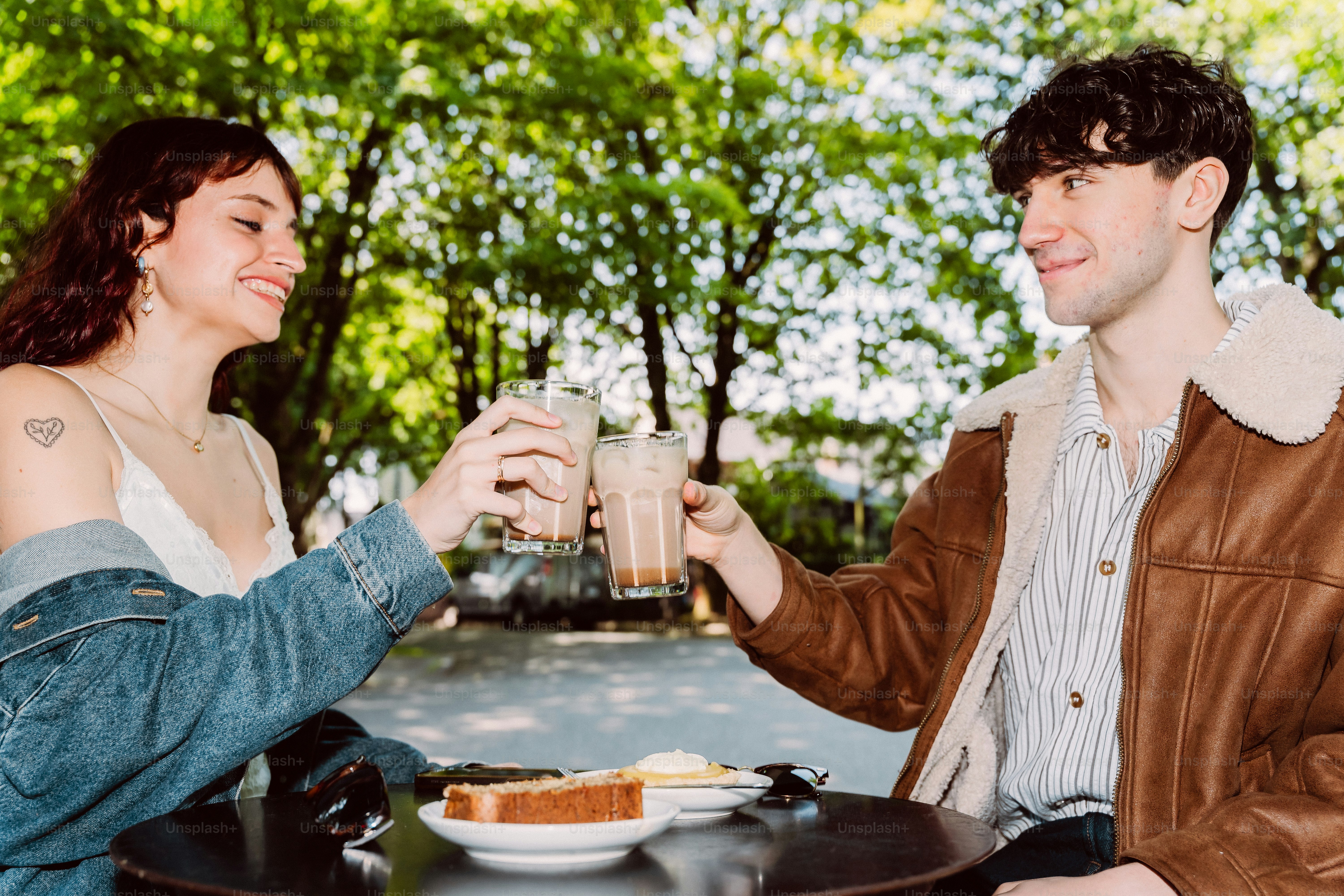 People toasting iced coffees at outdoor cafe