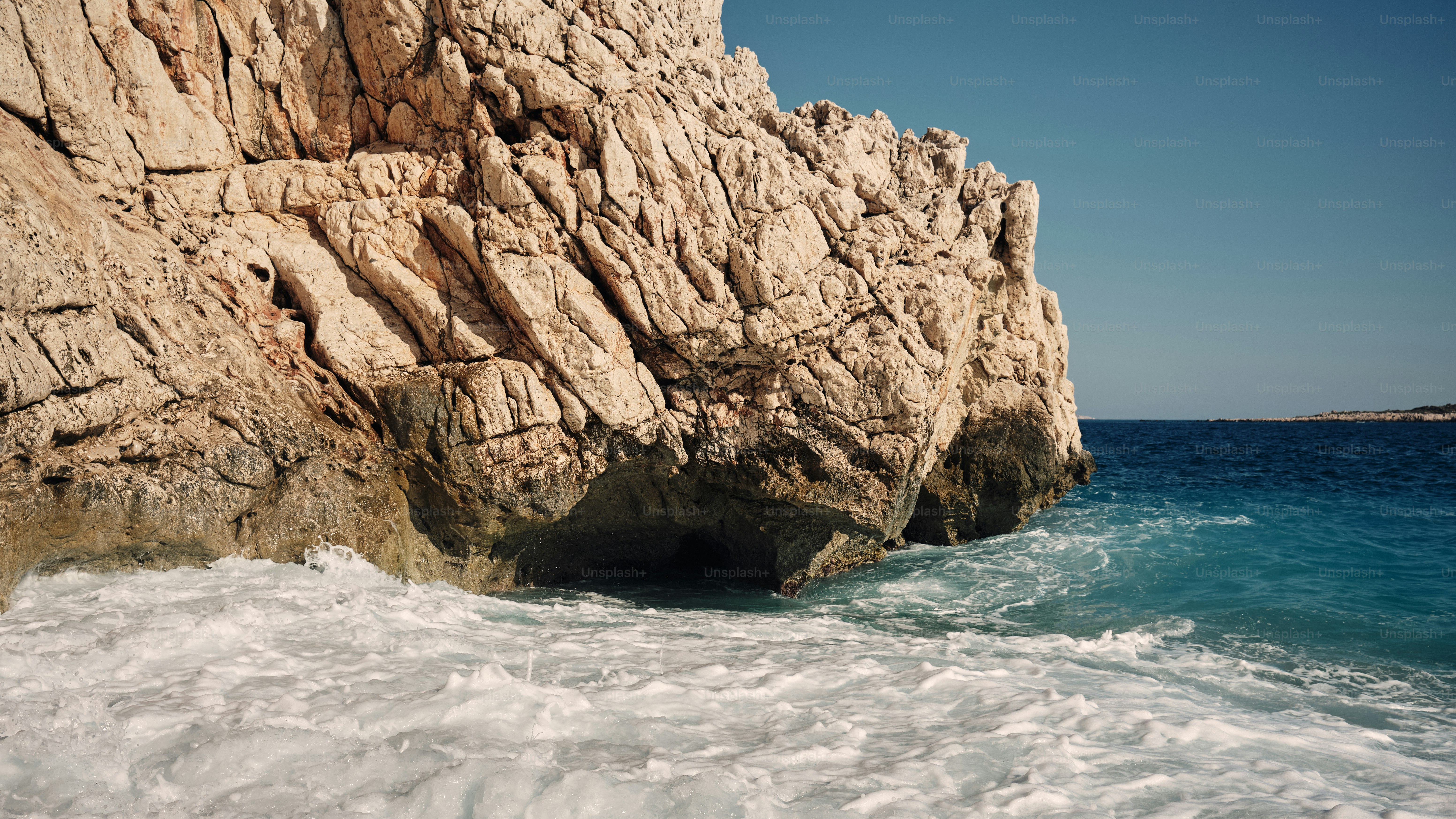 Ocean waves crashing against rugged cliff