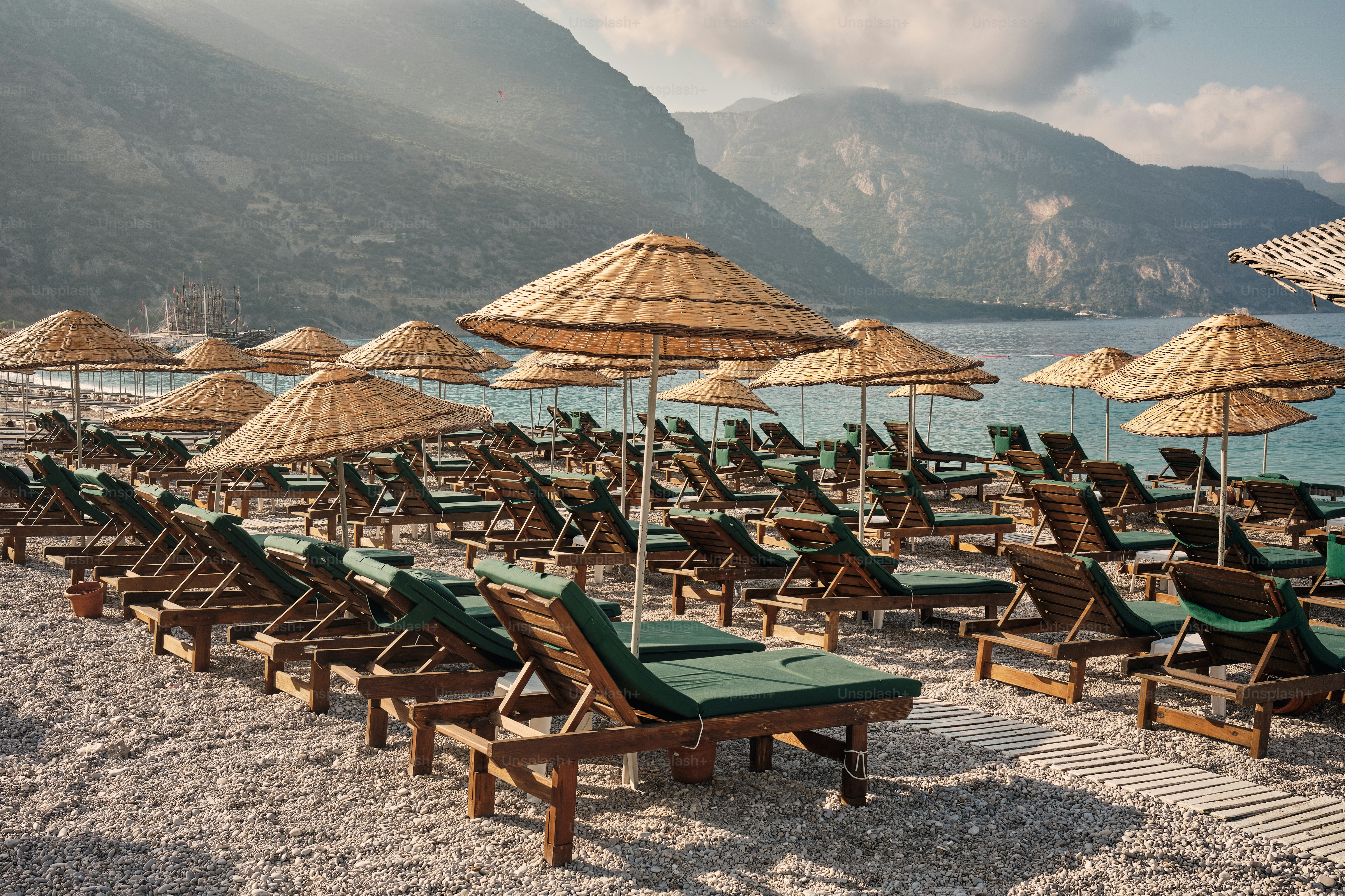 Straw umbrellas and lounge chairs on a summer beach