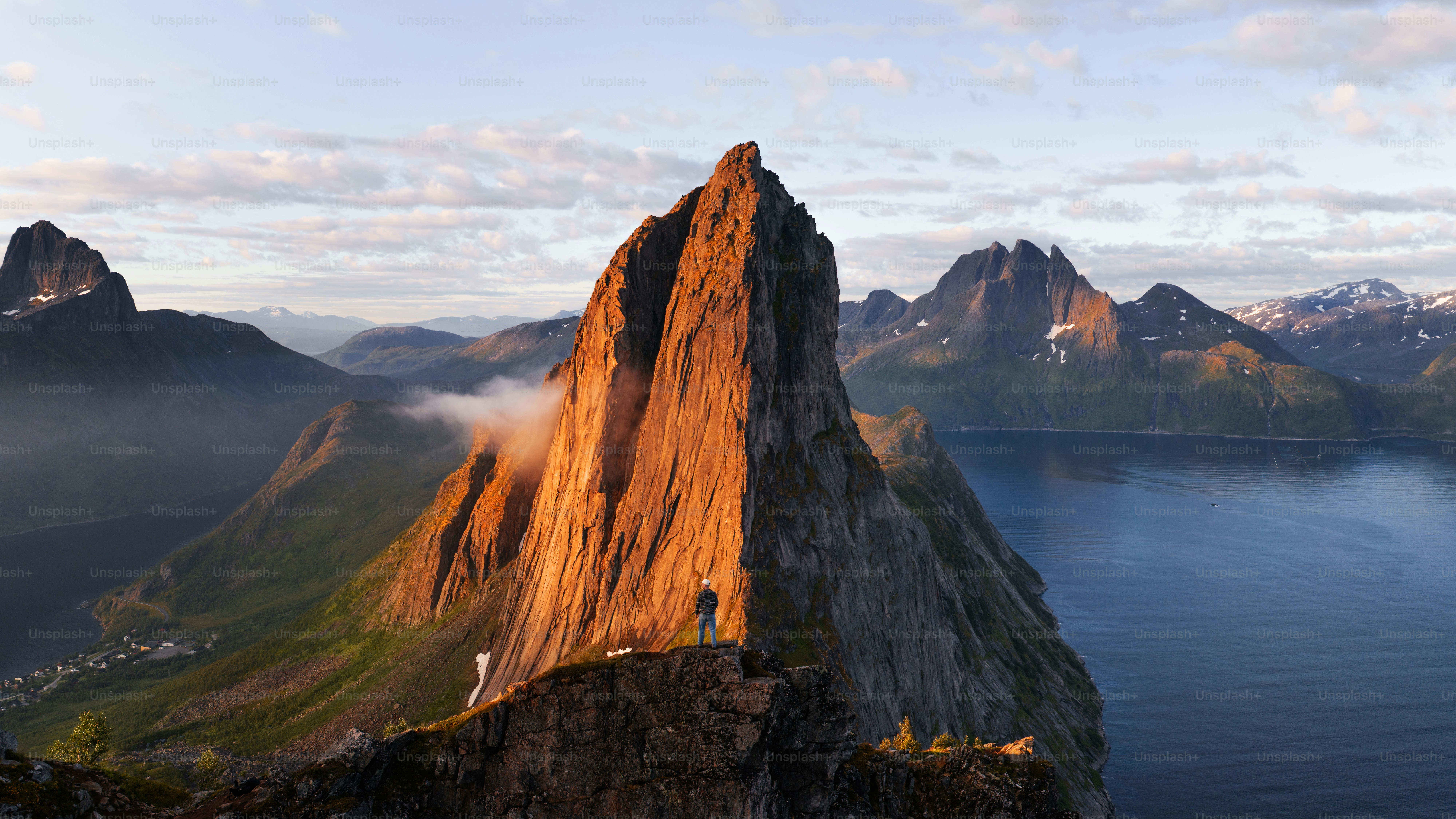 Golden light on sharp mountain peak overlooking water