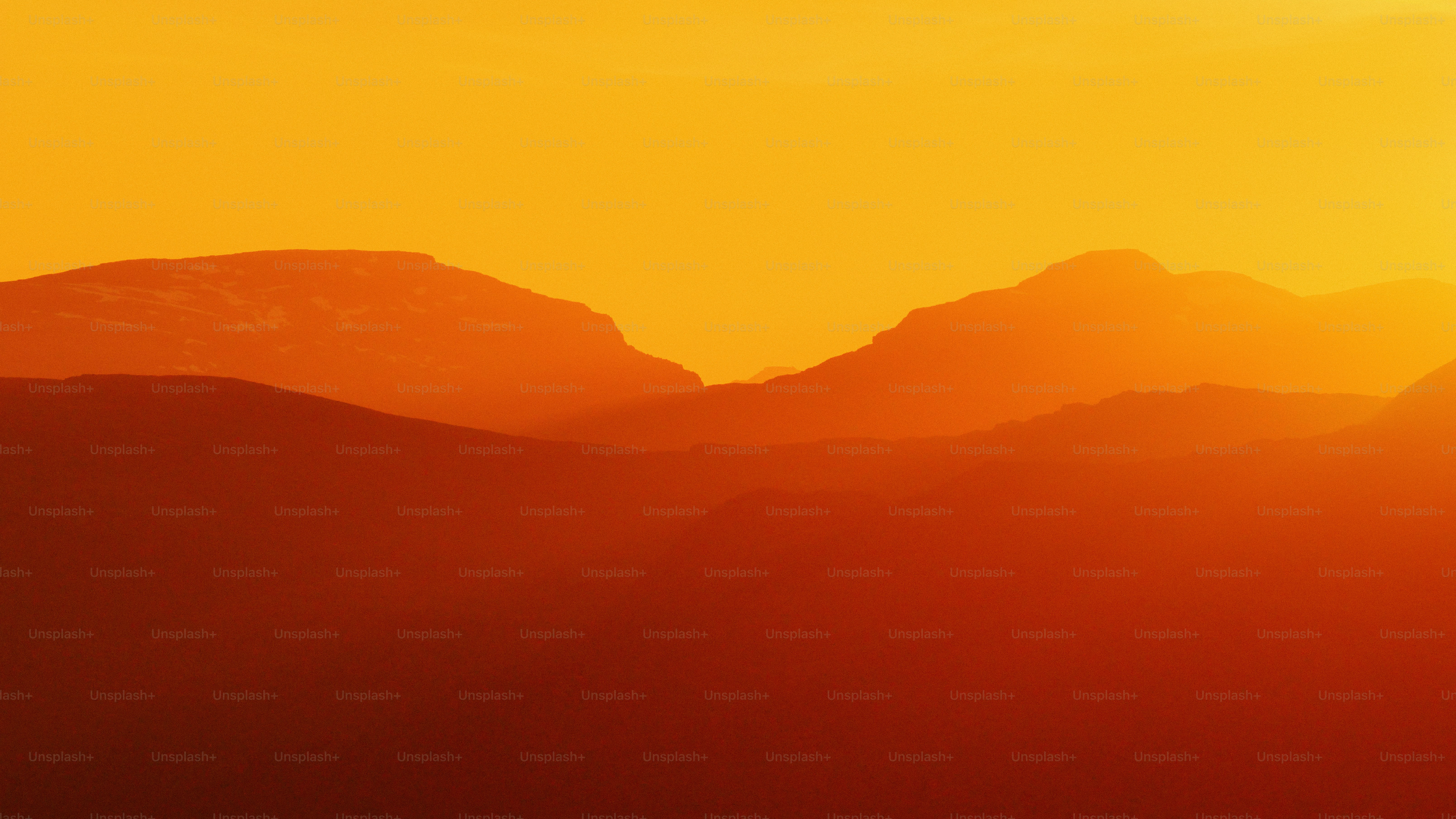 Mountain silhouettes against a fiery orange sunset