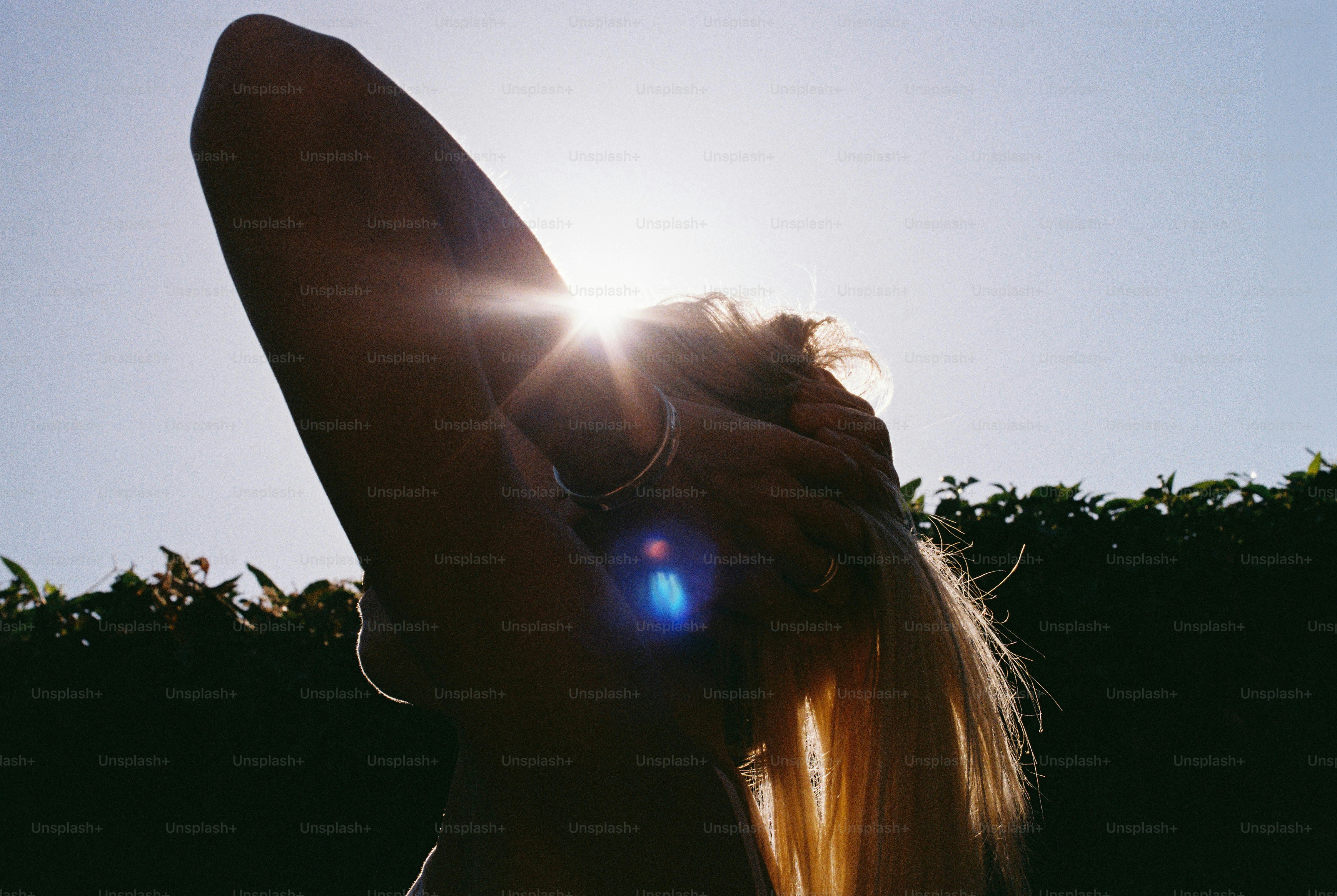 Blonde hair backlit by bright sun with lens flare