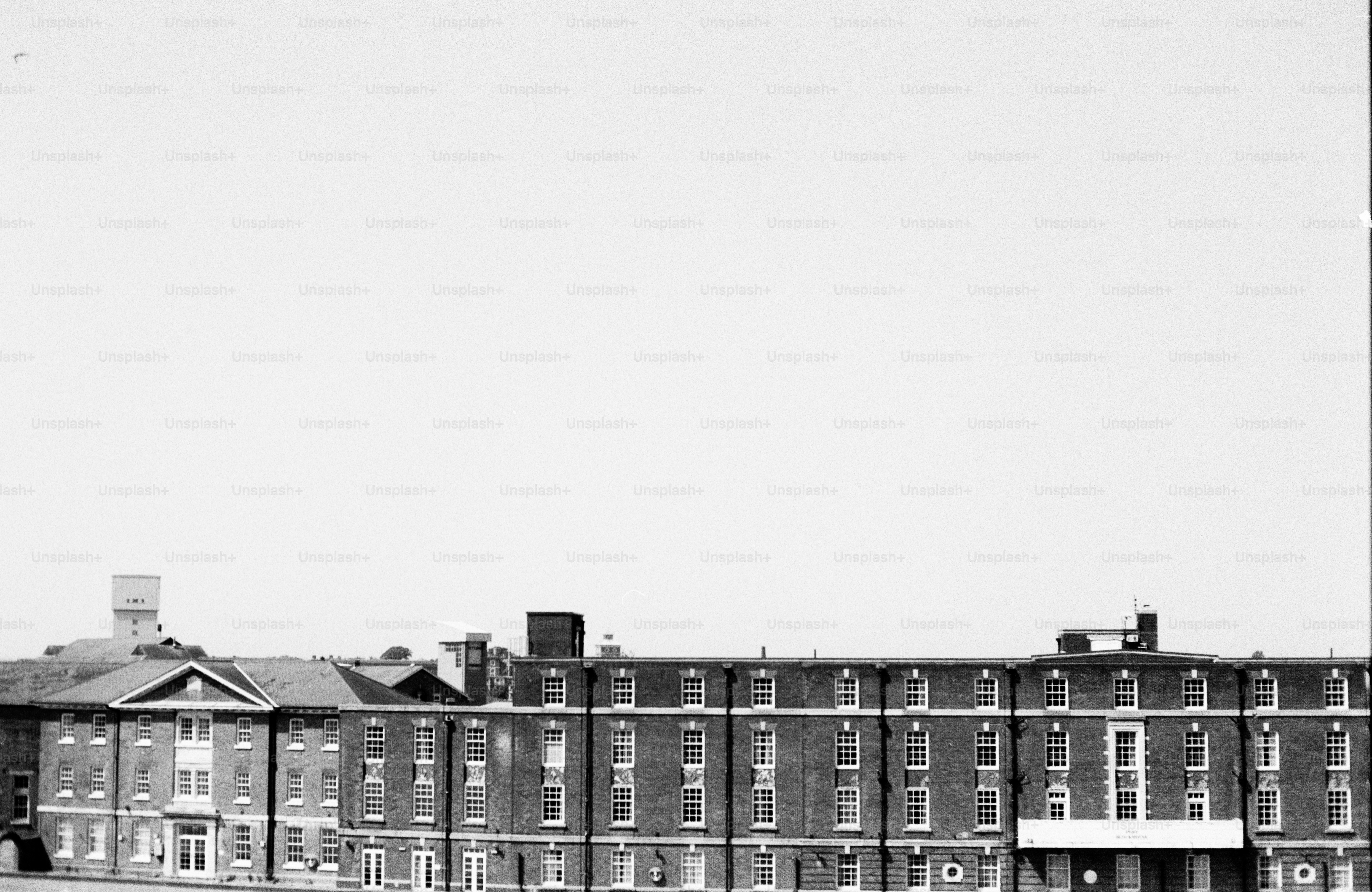 Historic brick building with numerous windows, black and white