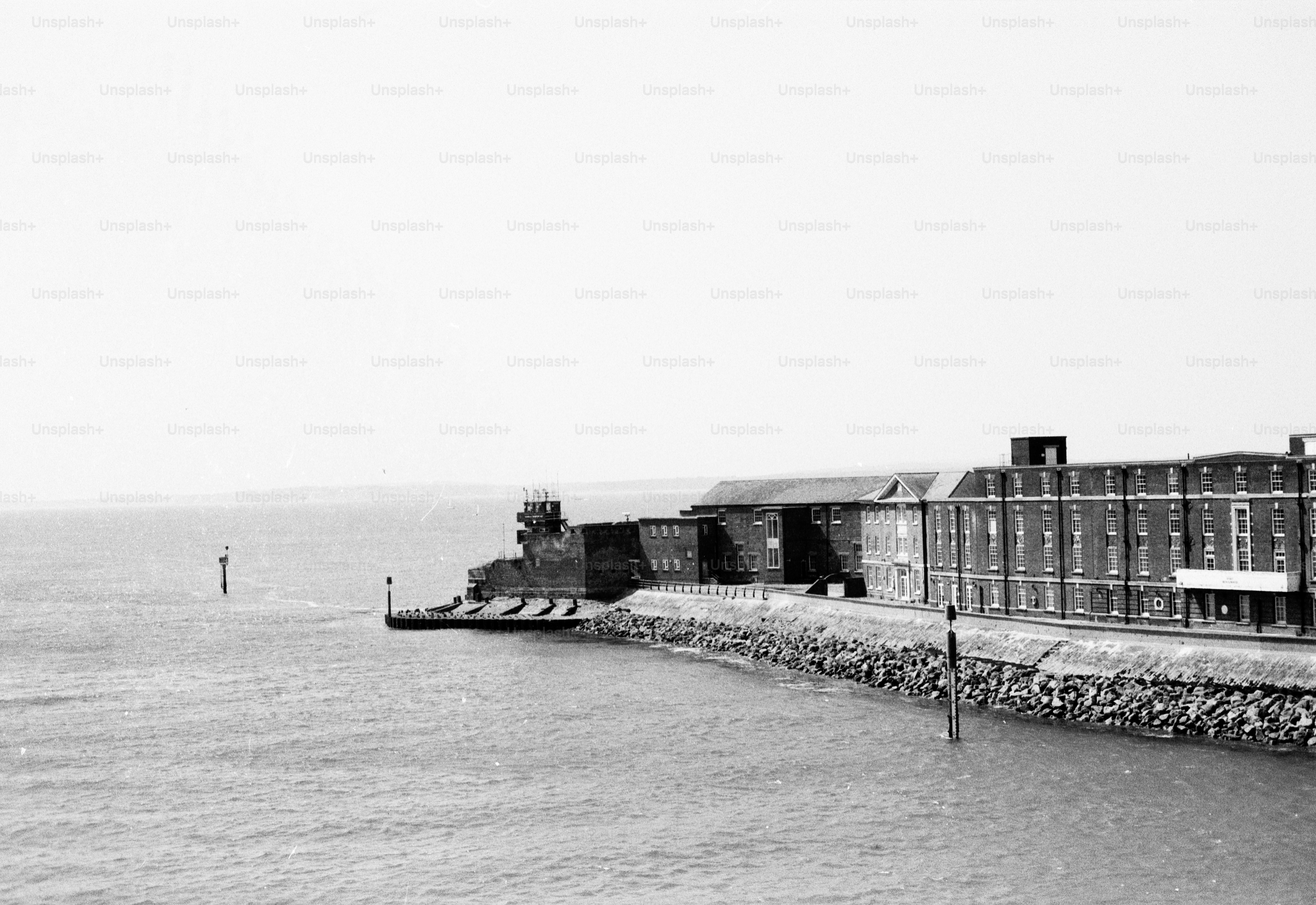 Black and white coastal building and rocky shore