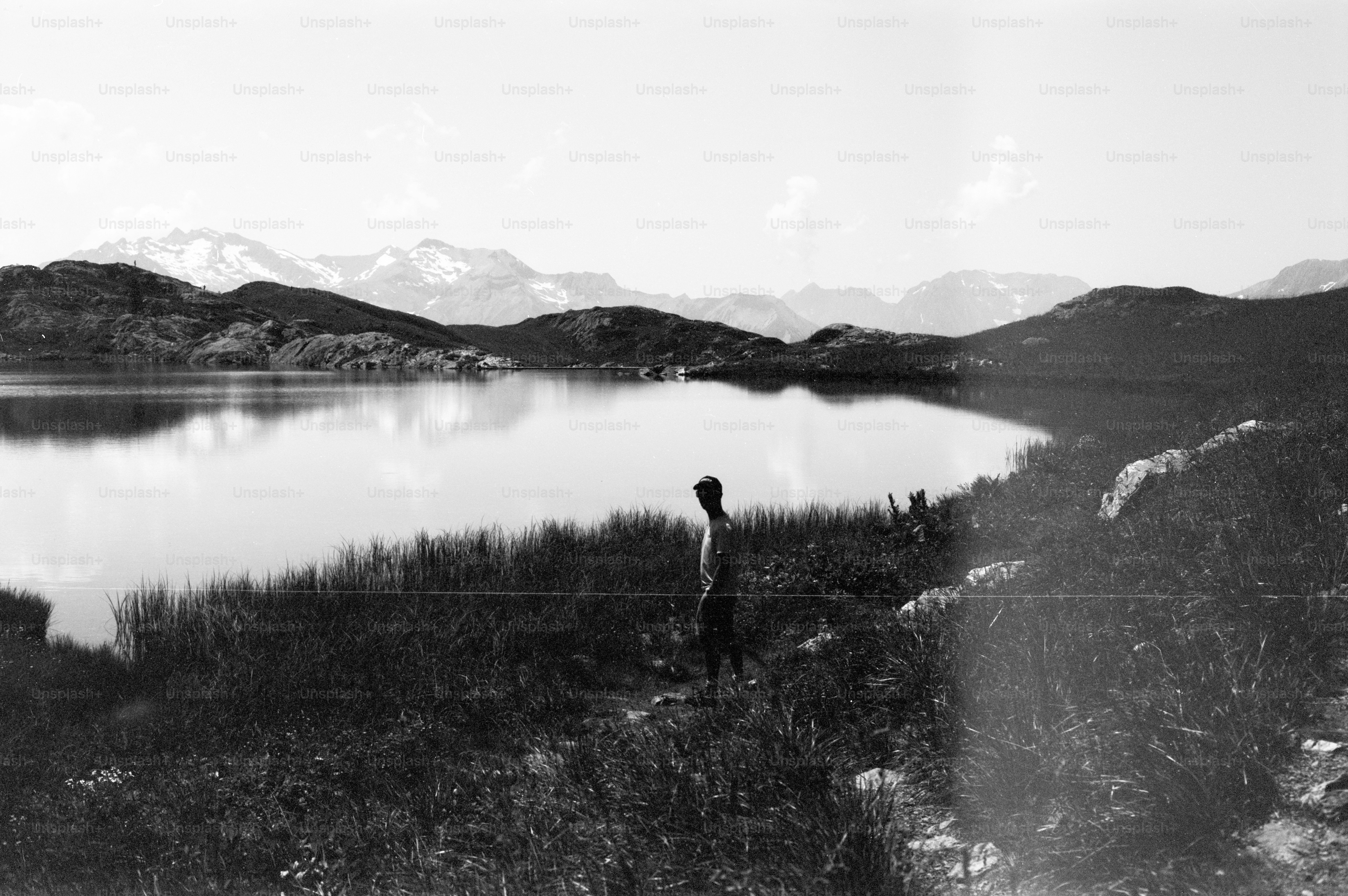 Figure by mountain lake, black and white