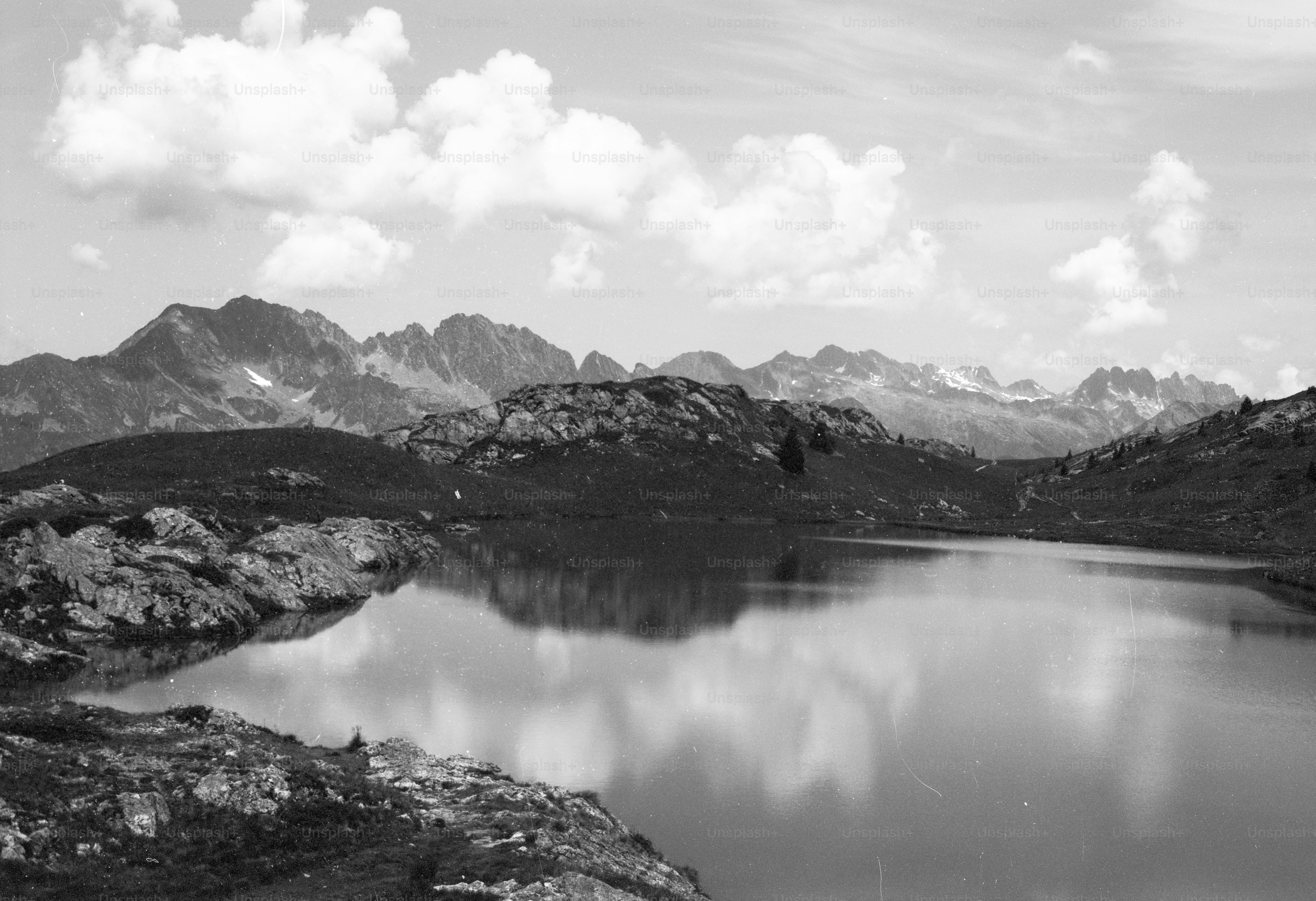 Serene mountain lake reflecting clouds and peaks