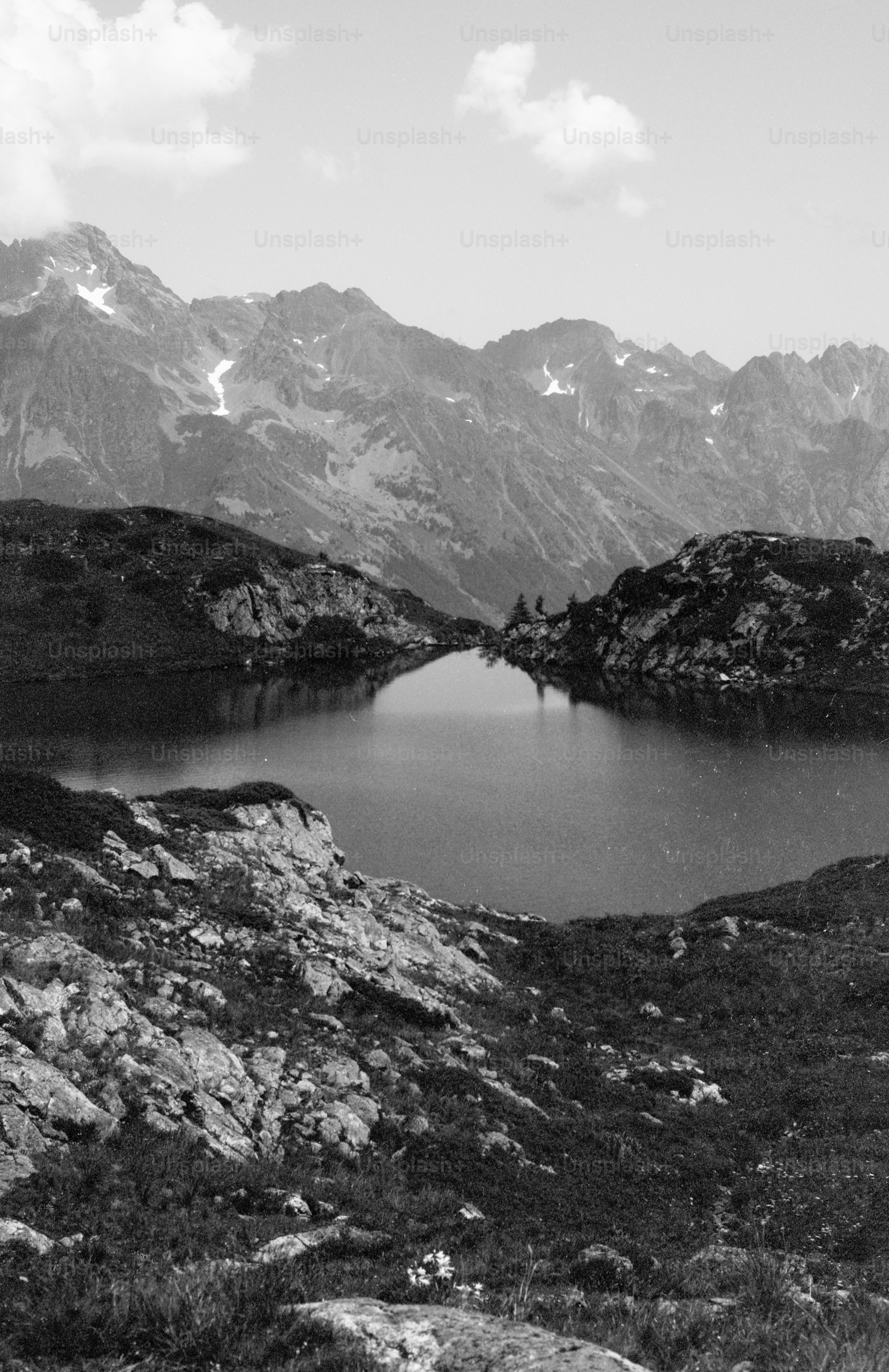 Serene mountain lake reflecting distant snow-capped peaks