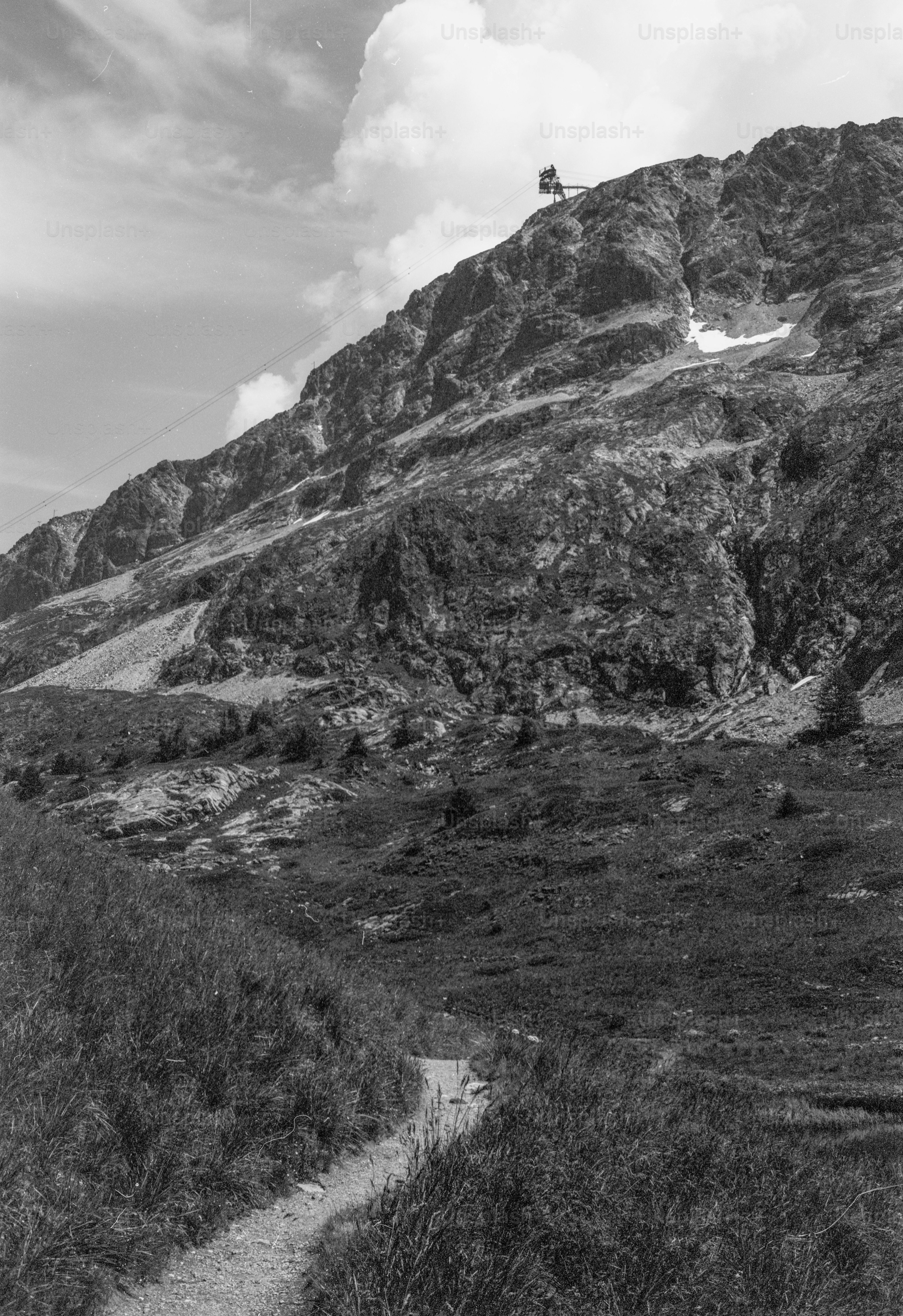 Path leading up rocky mountain to summit building