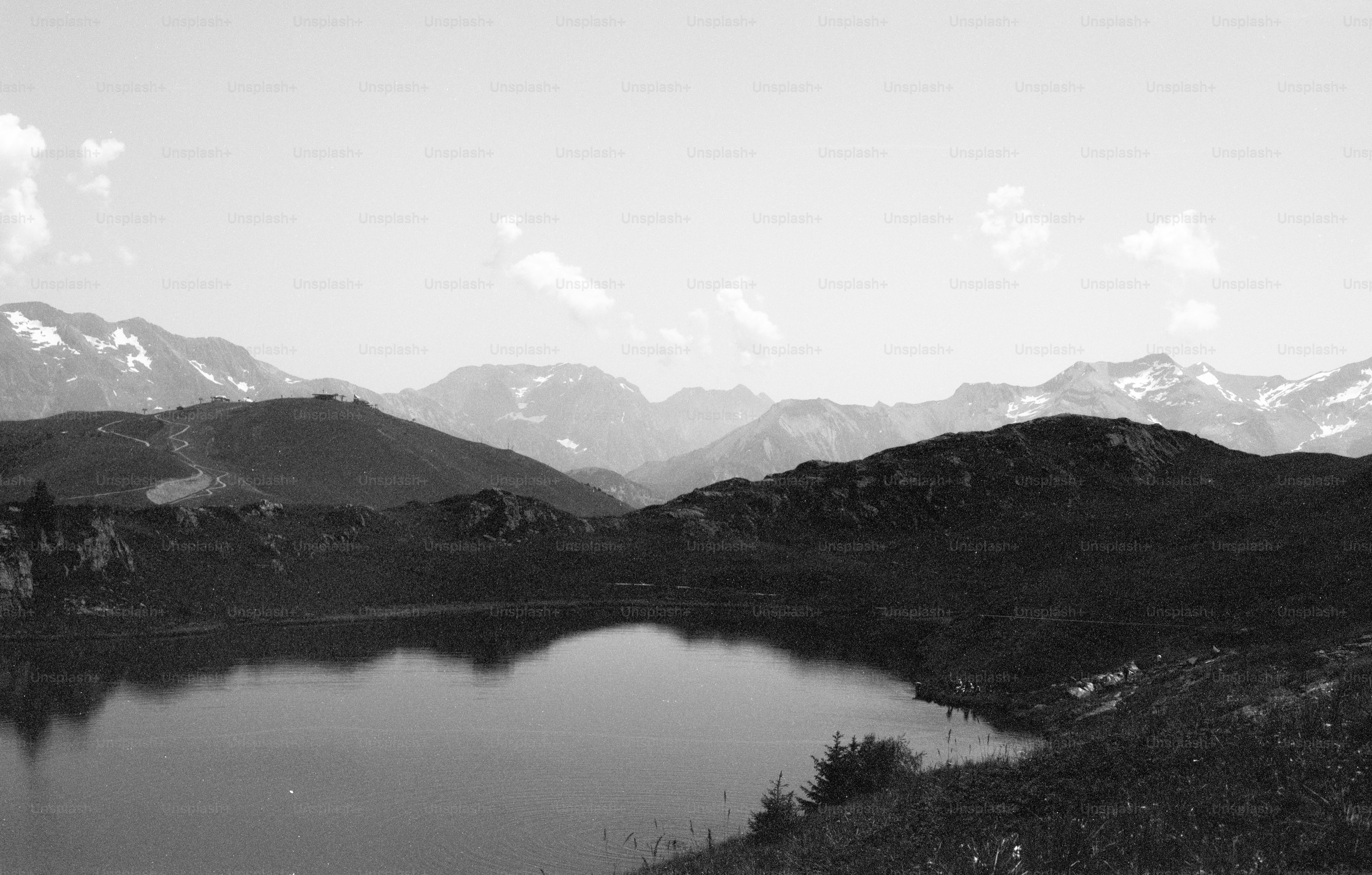 Monochrome lake and distant snow-capped mountains