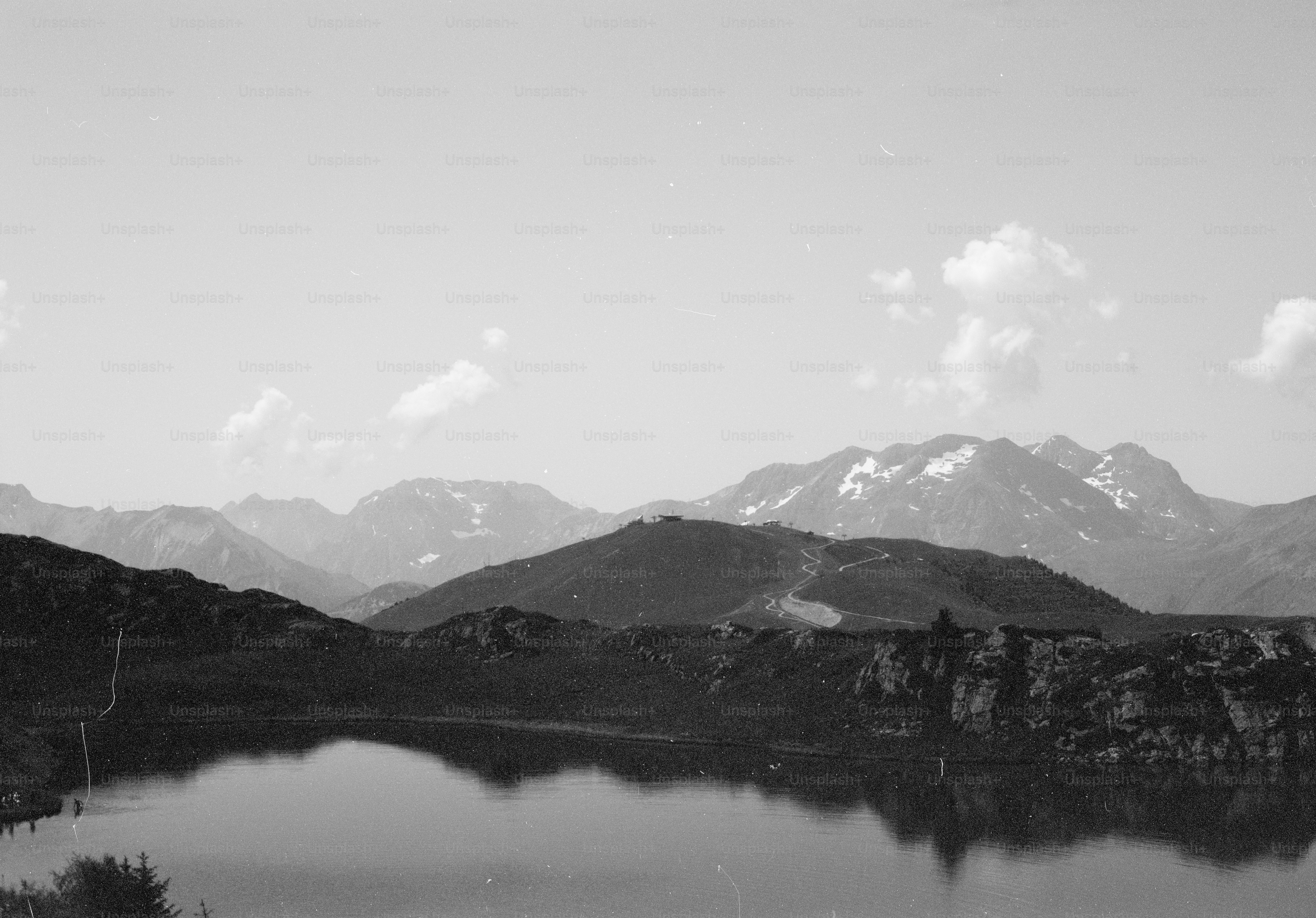Monochrome landscape with lake reflecting snowy mountains