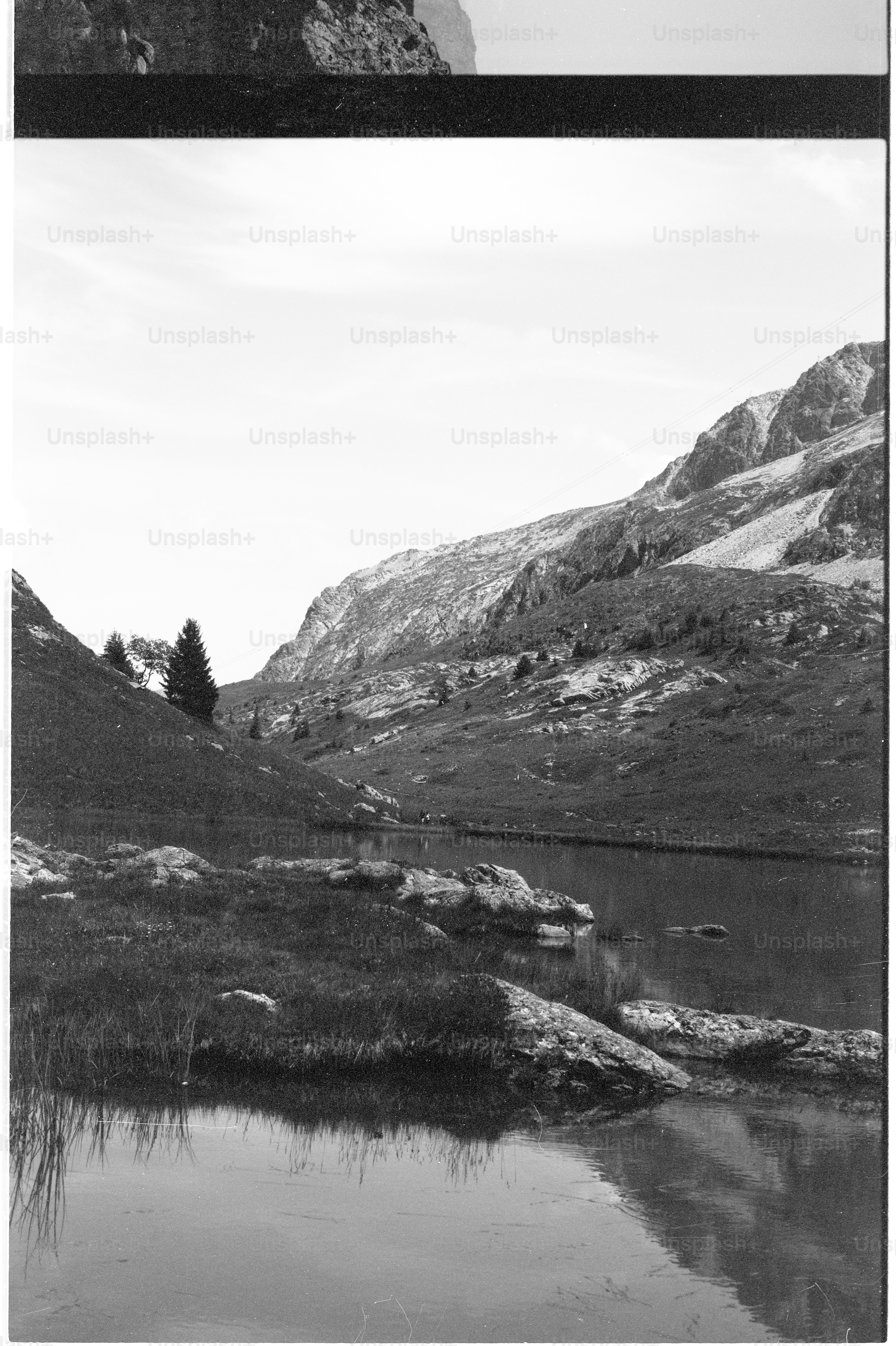 Mountain lake with rocky shore, black and white
