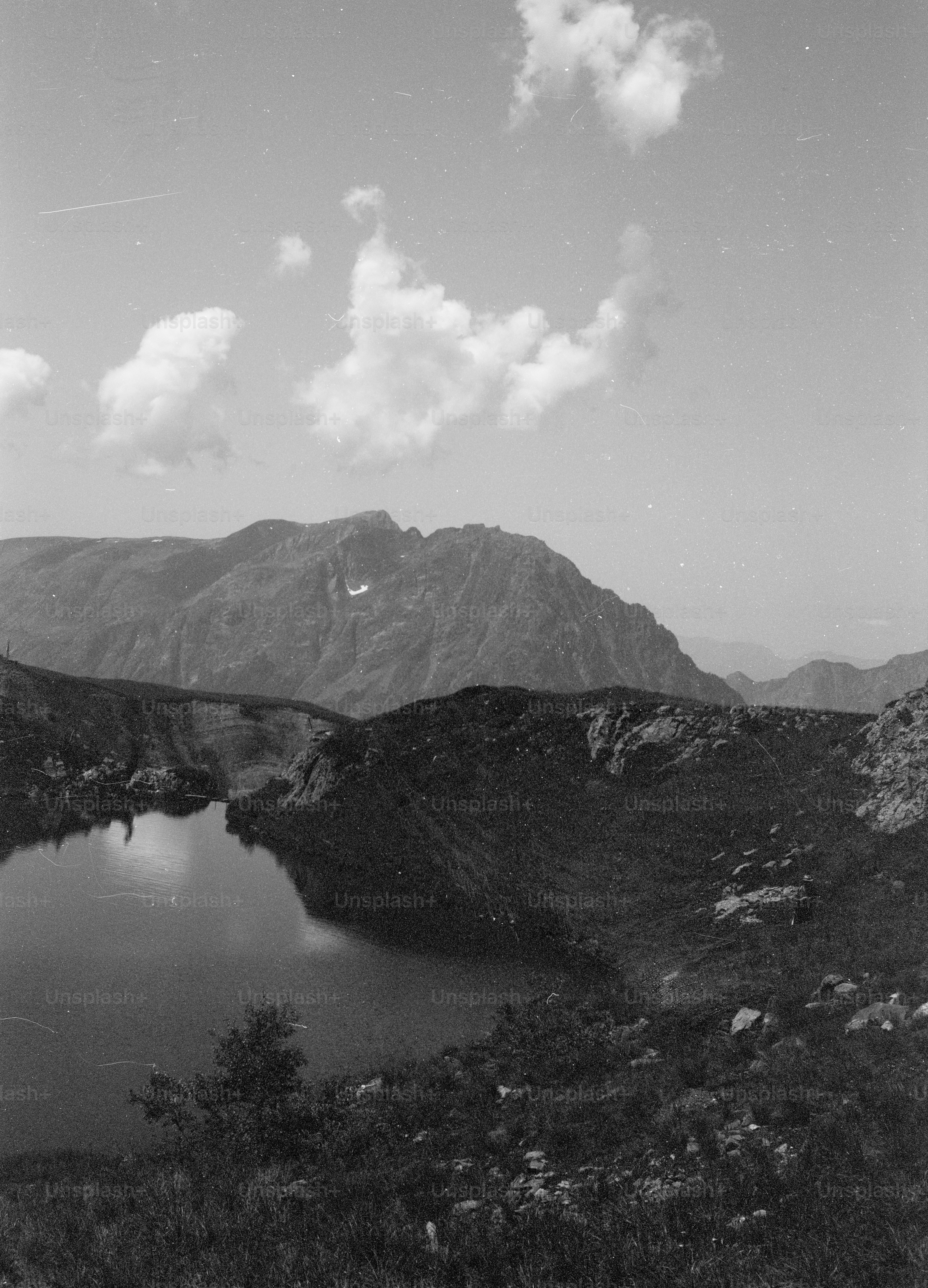 Black and white mountain lake under cloudy sky