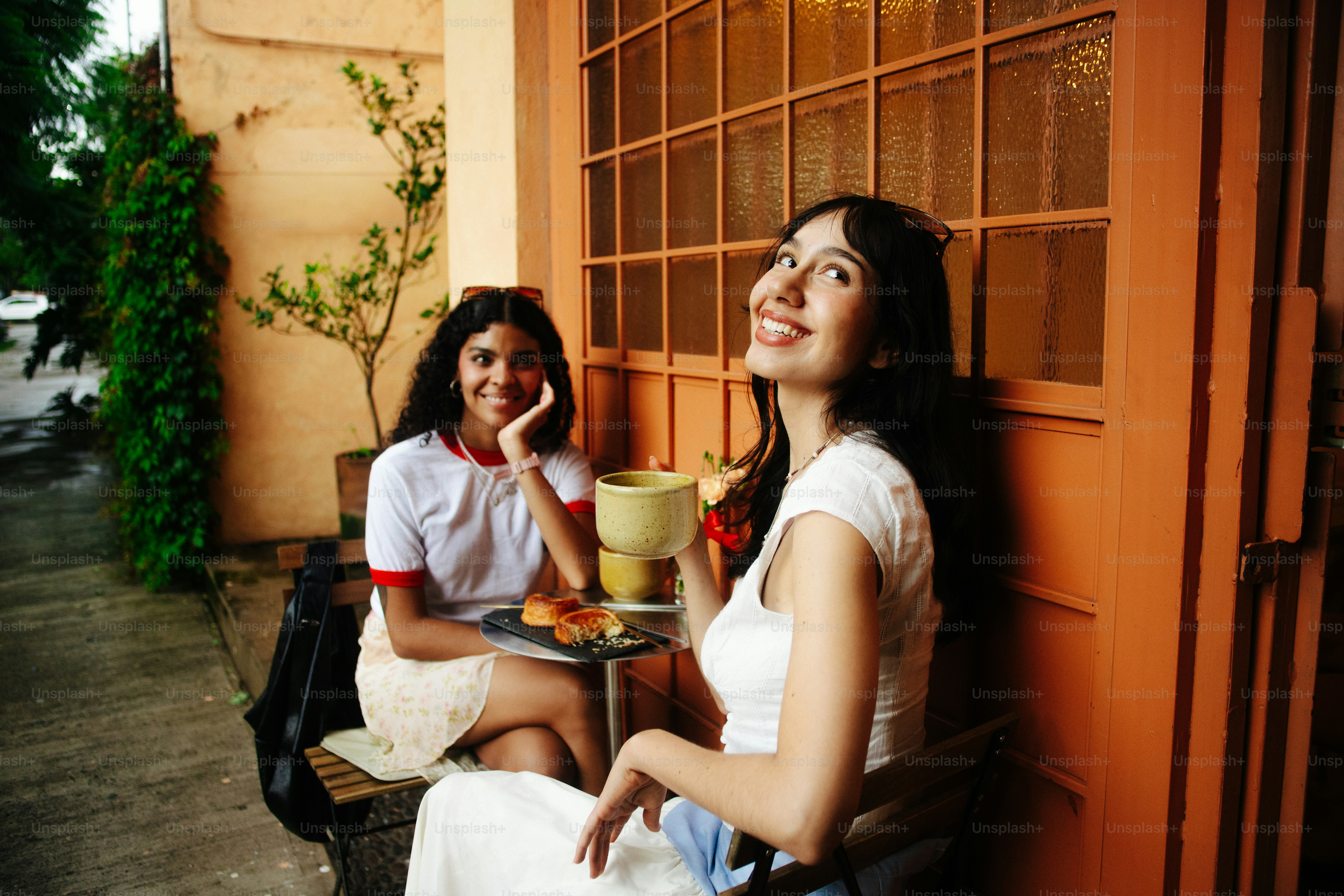 Des femmes souriantes profitant du café et des pâtisseries au café