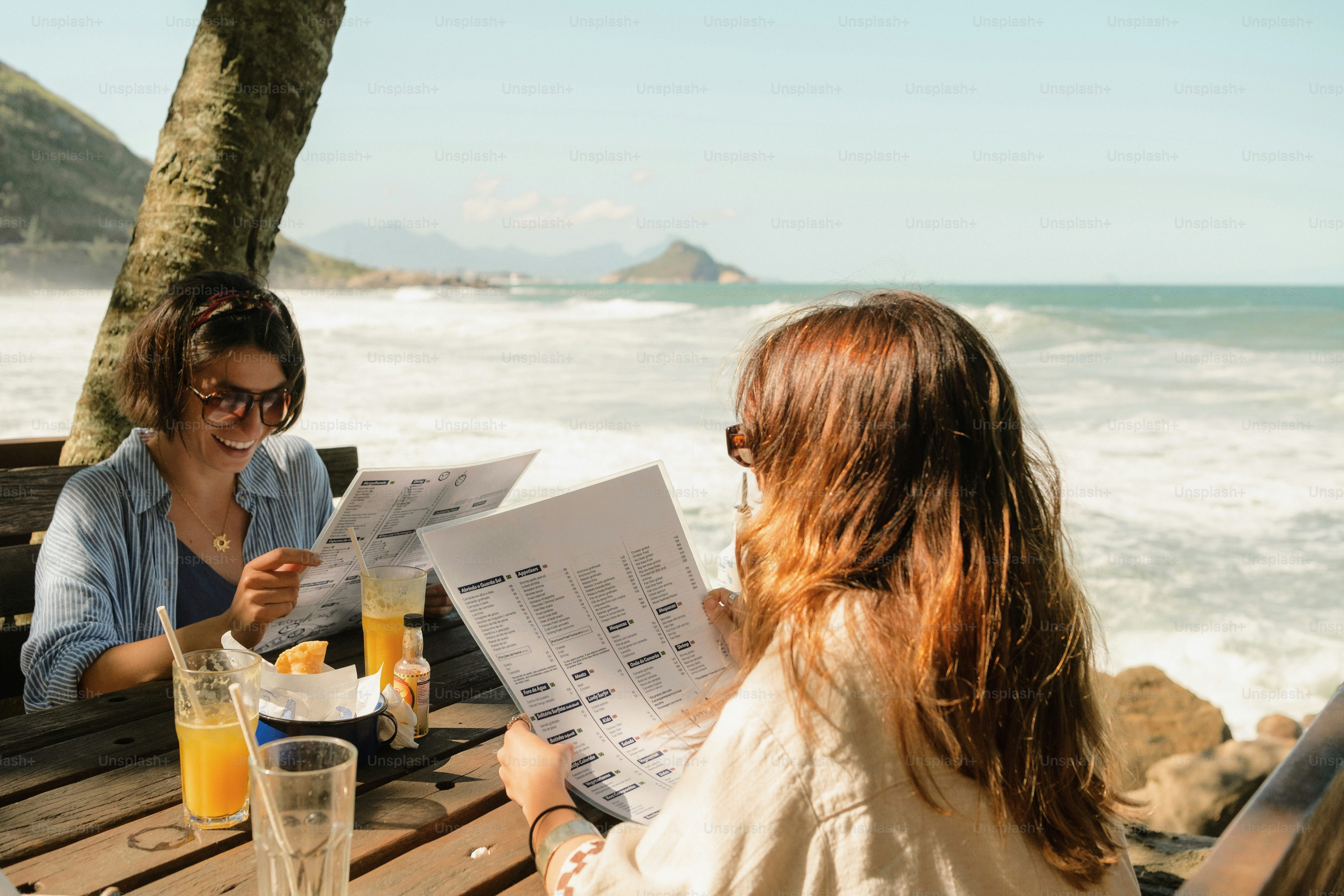 Women reading menus at a beachside restaurant