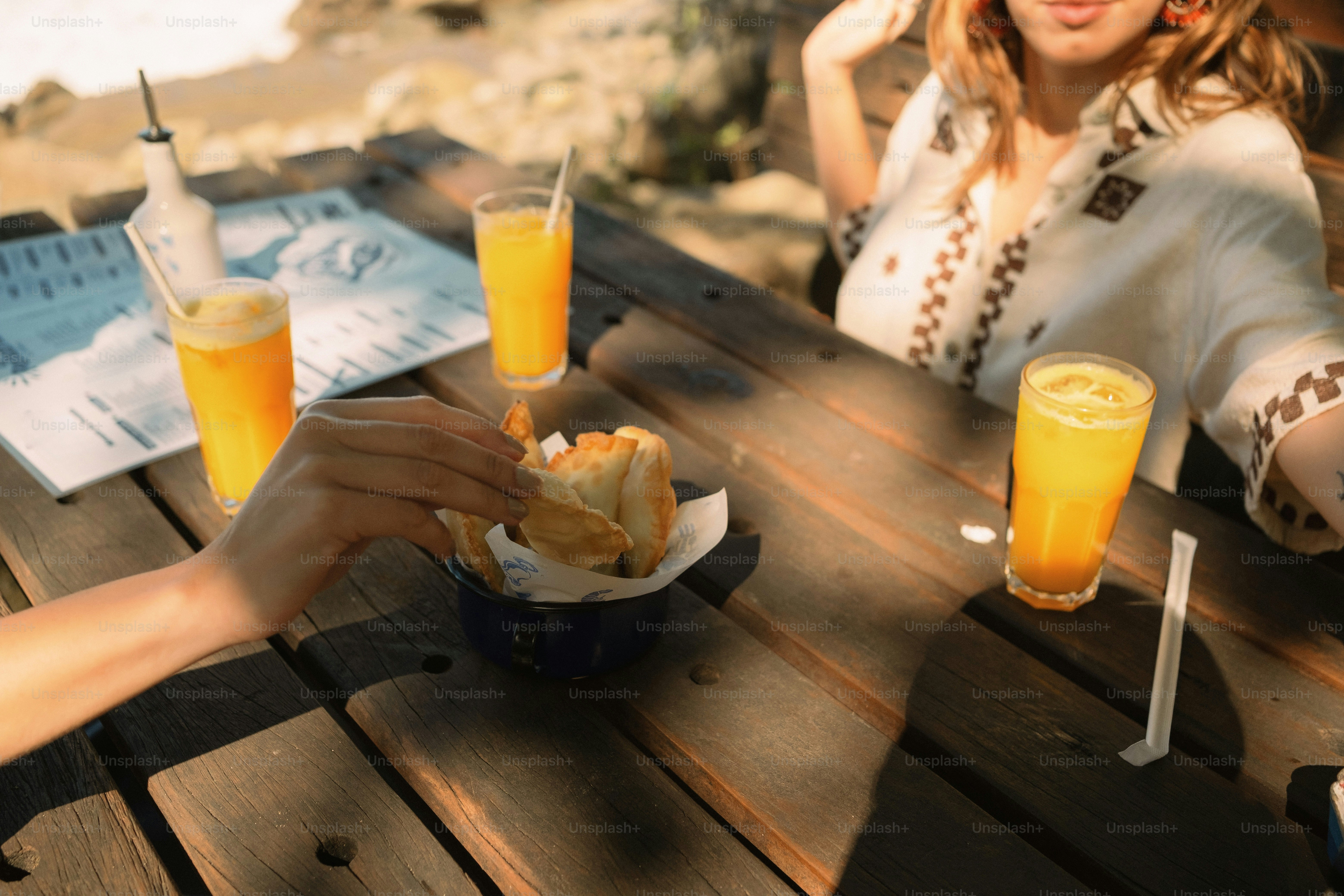 People eating bread and drinking juice outdoors