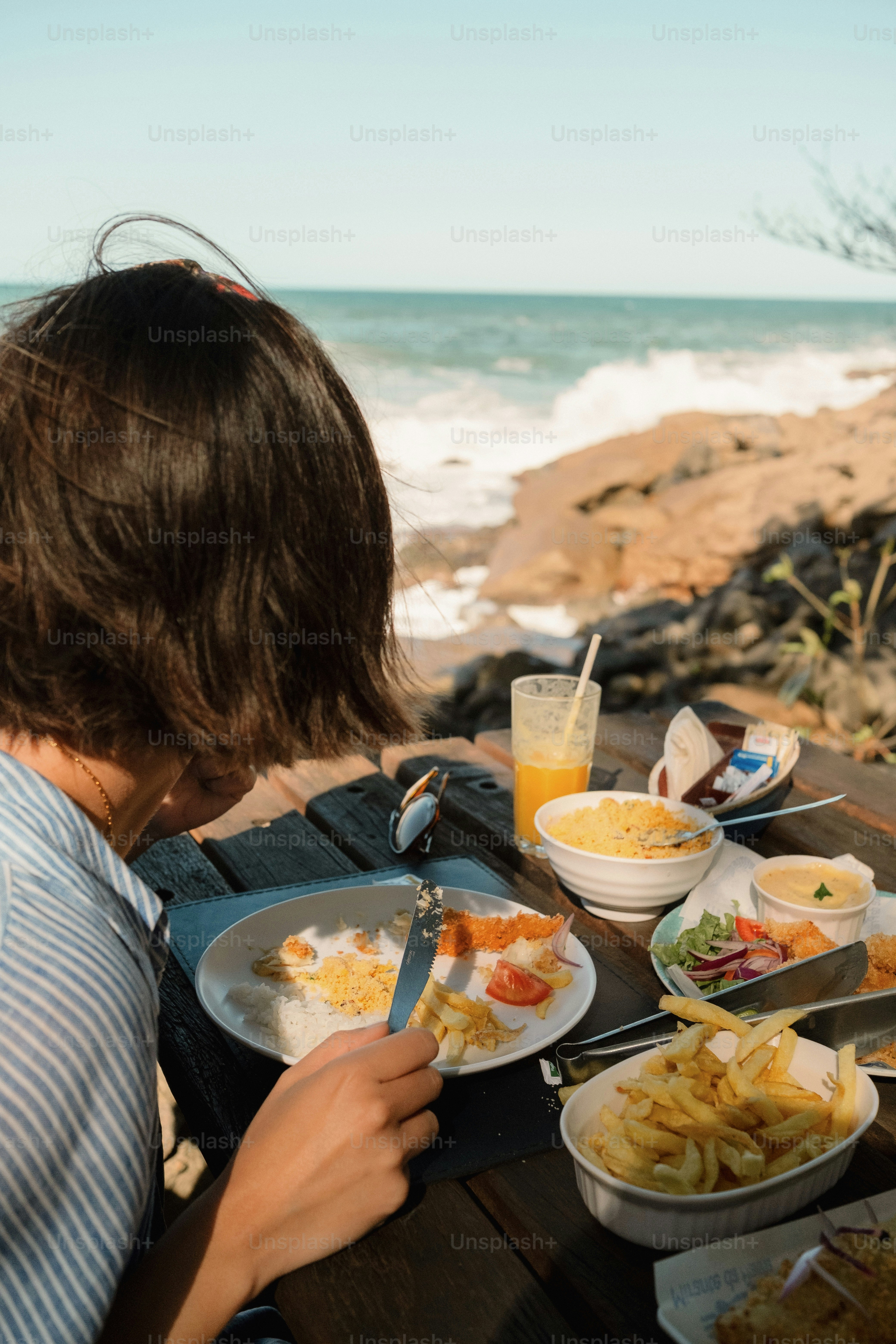 Woman enjoying a meal at a beachfront table