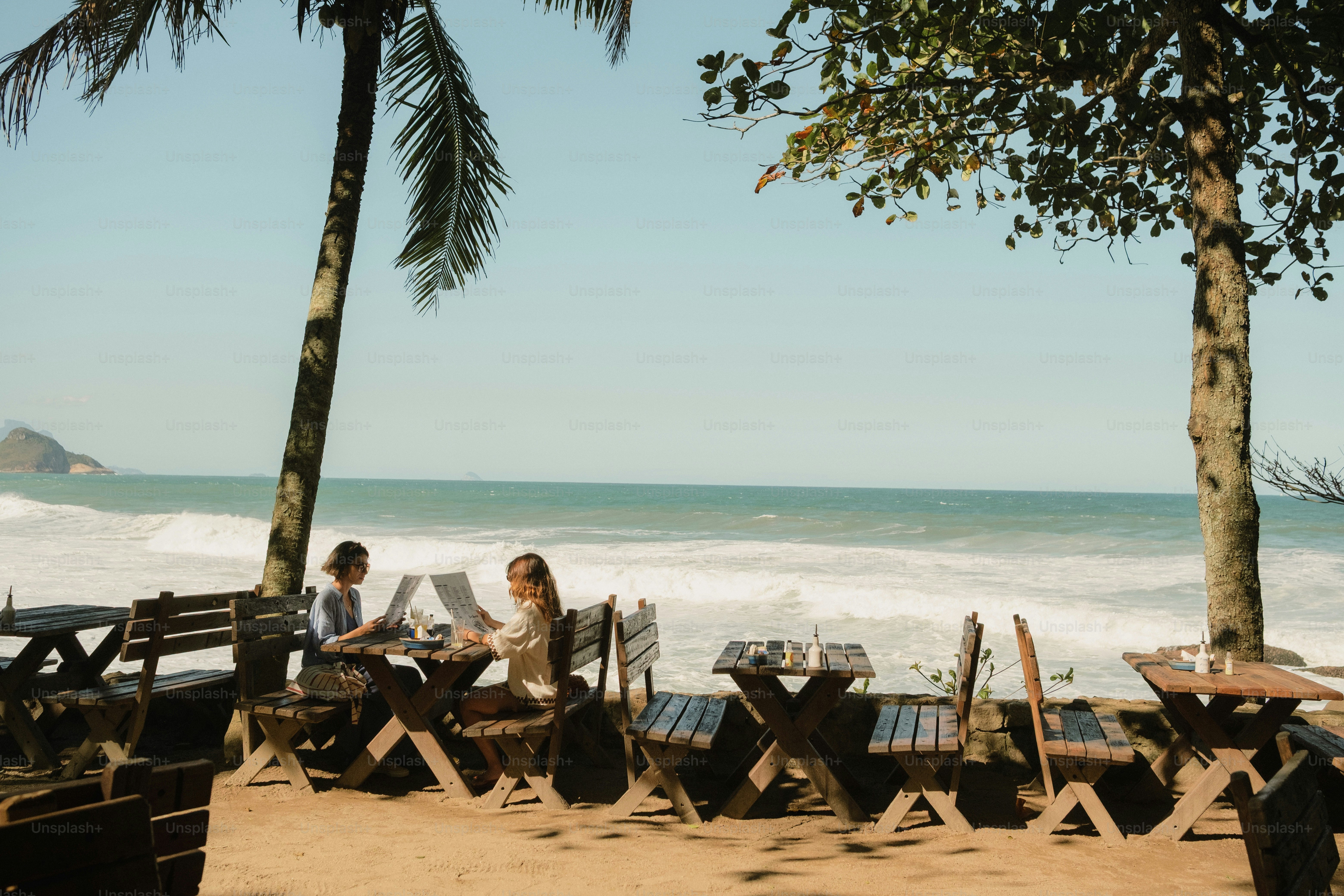 Women dining at beach cafe with ocean view