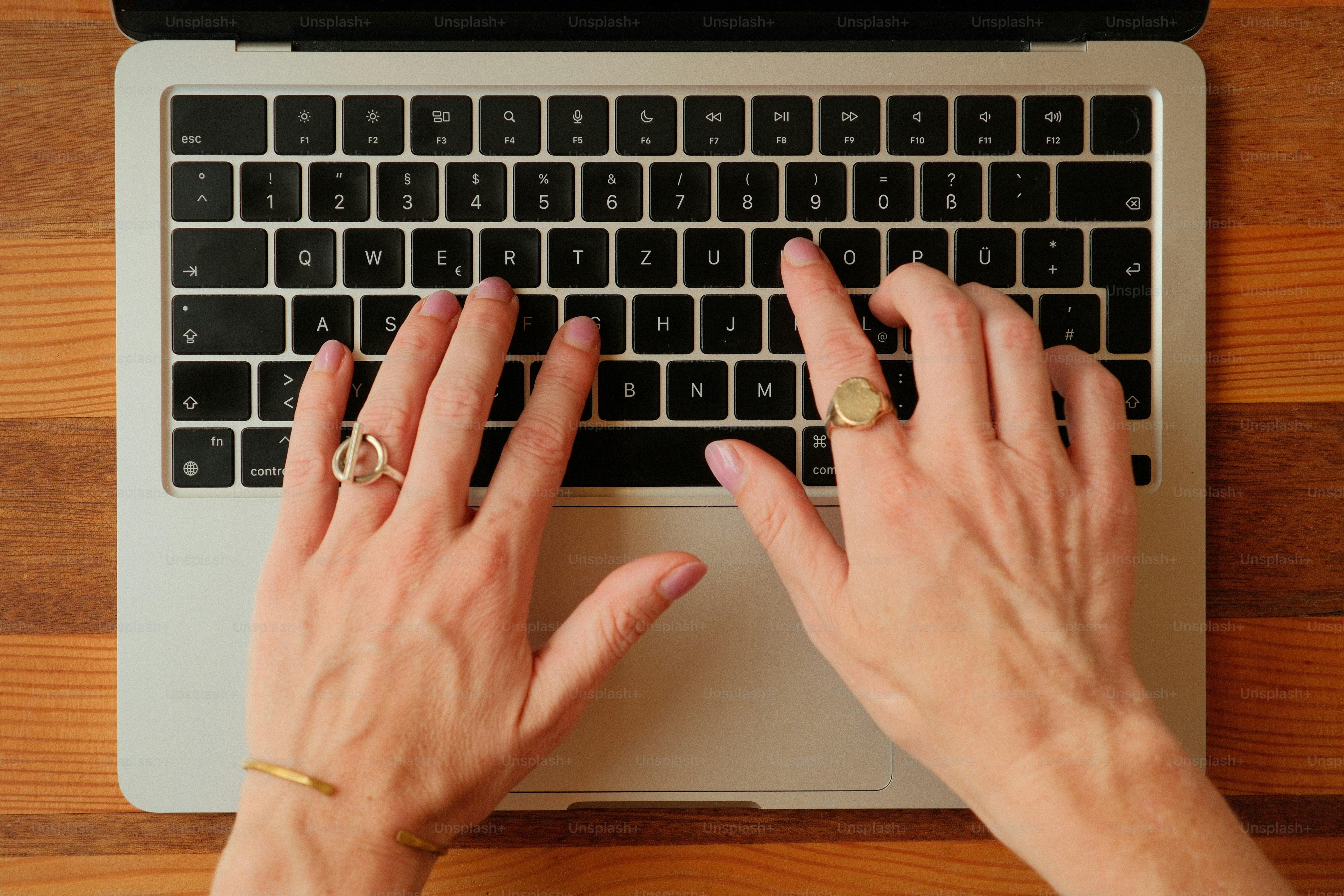Hands typing on a laptop keyboard