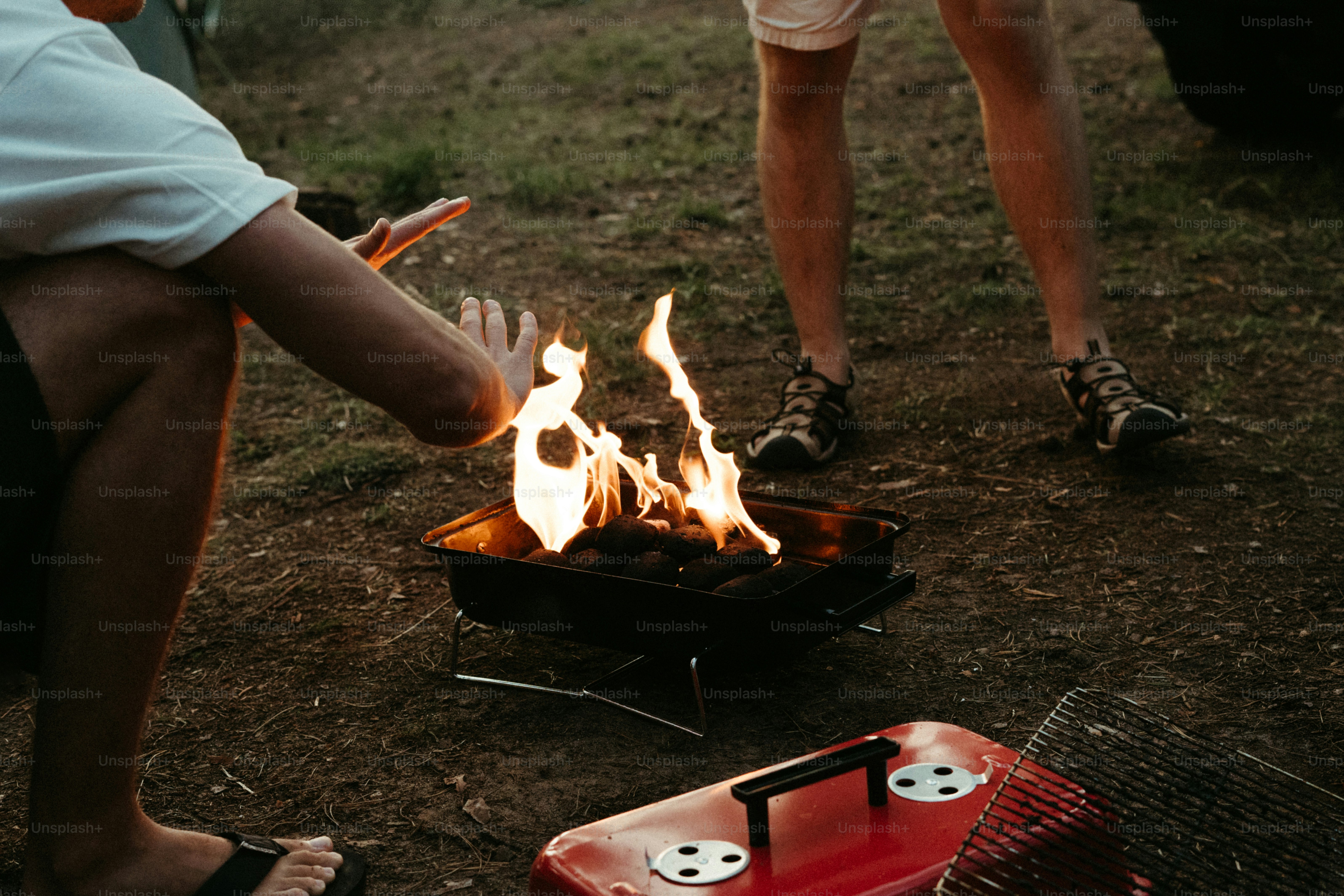 People warming hands around a small outdoor fire