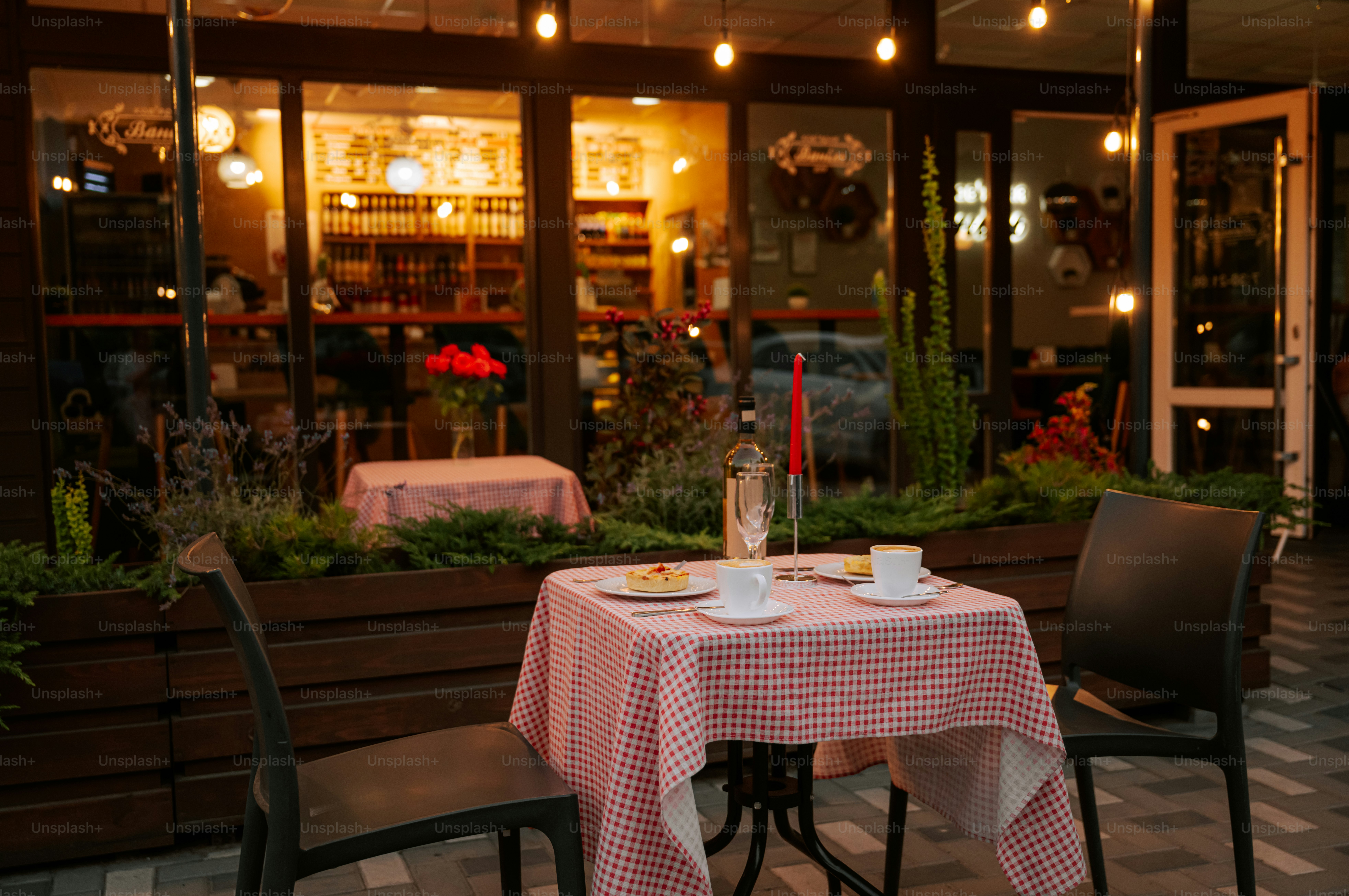 Outdoor cafe table with checkered cloth, glowing restaurant lights