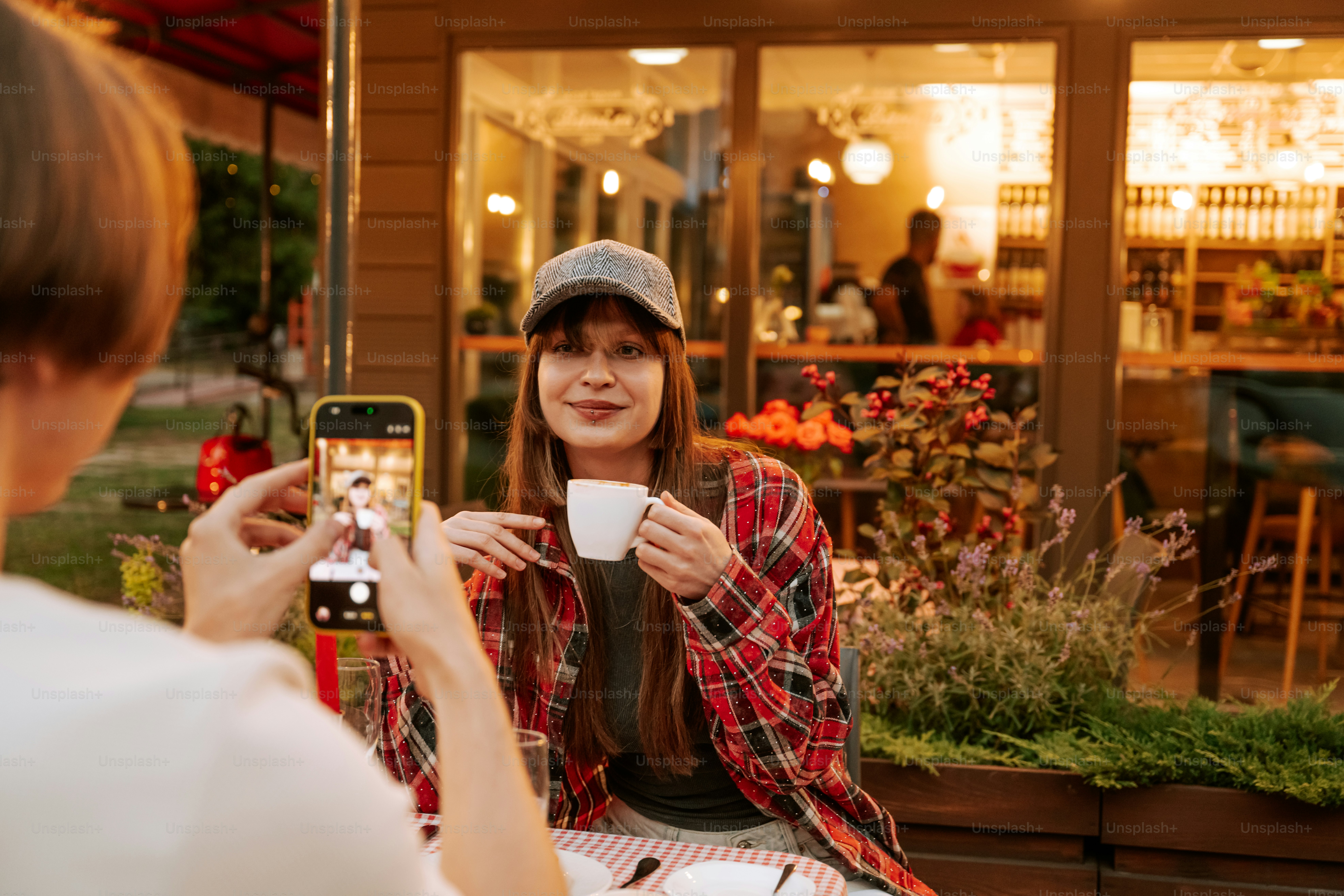Friends taking photos at outdoor cafe